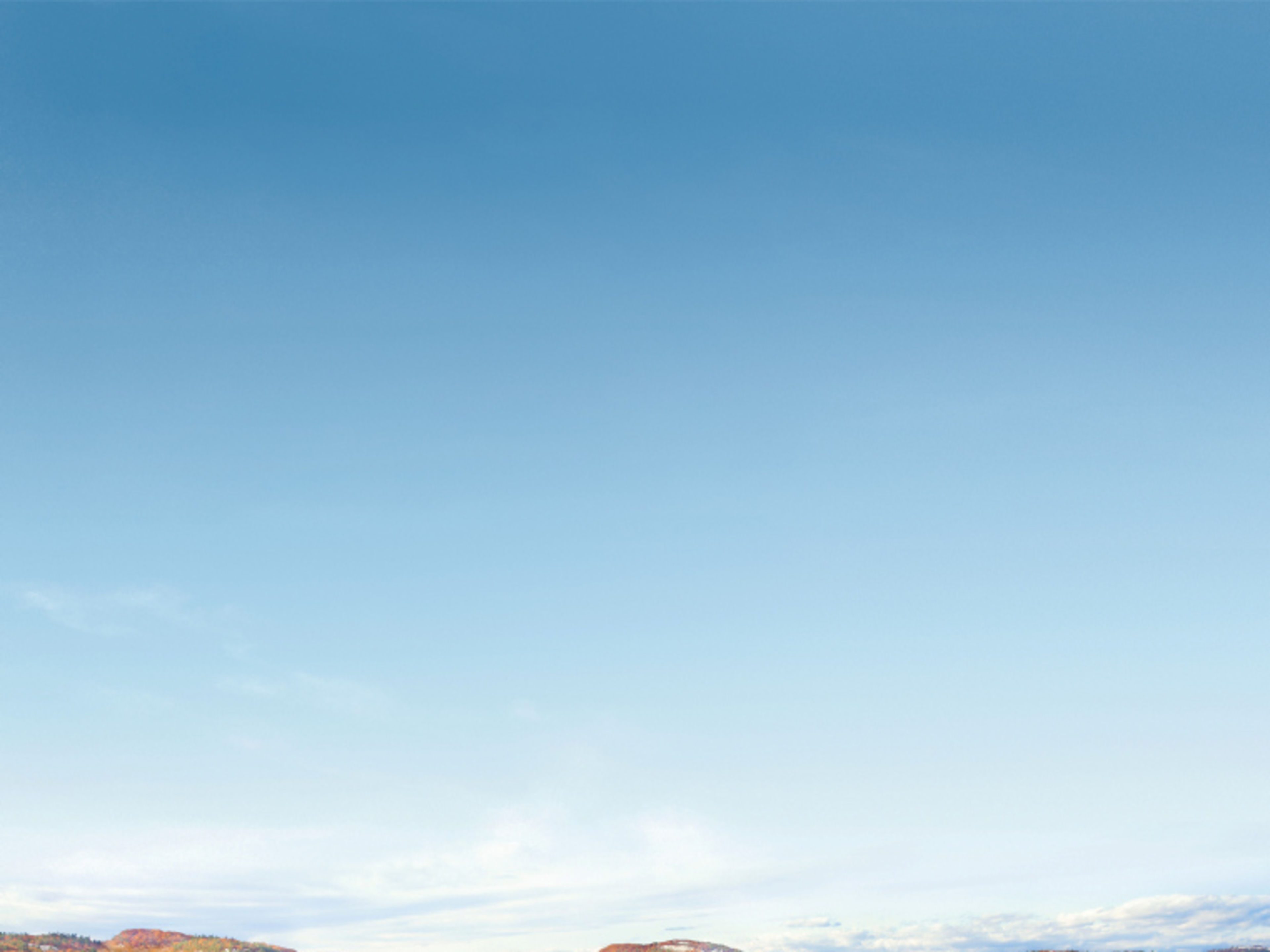 Indian Summer in Kanada Herbstliche Landschaft mit See, bunten Bäumen und Bergen unter klarem Himmel.