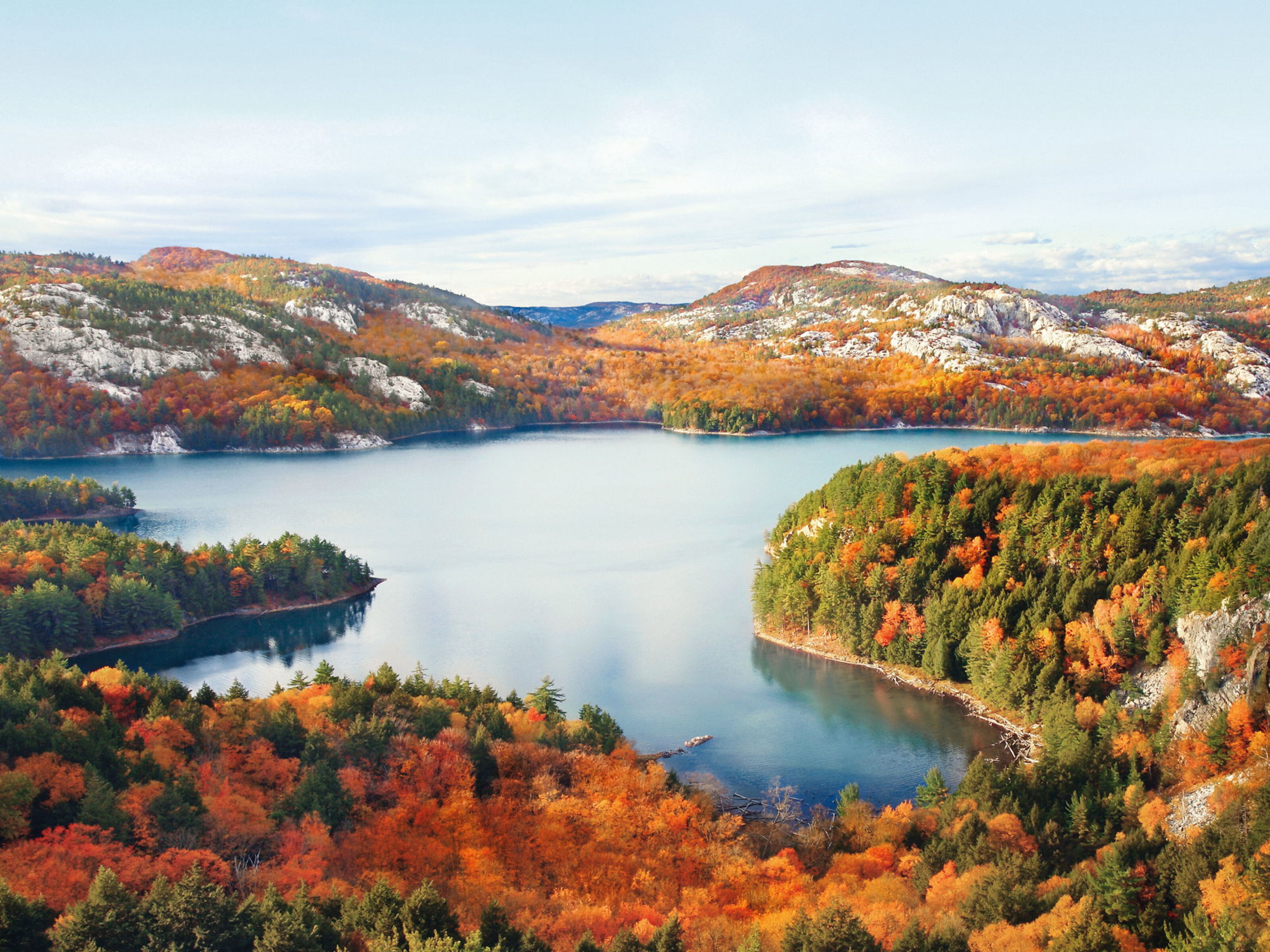 Herbstliche Landschaft mit See, bunten Bäumen und Bergen unter klarem Himmel. Herbstliche Landschaft mit See, bunten Bäumen und Bergen unter klarem Himmel.