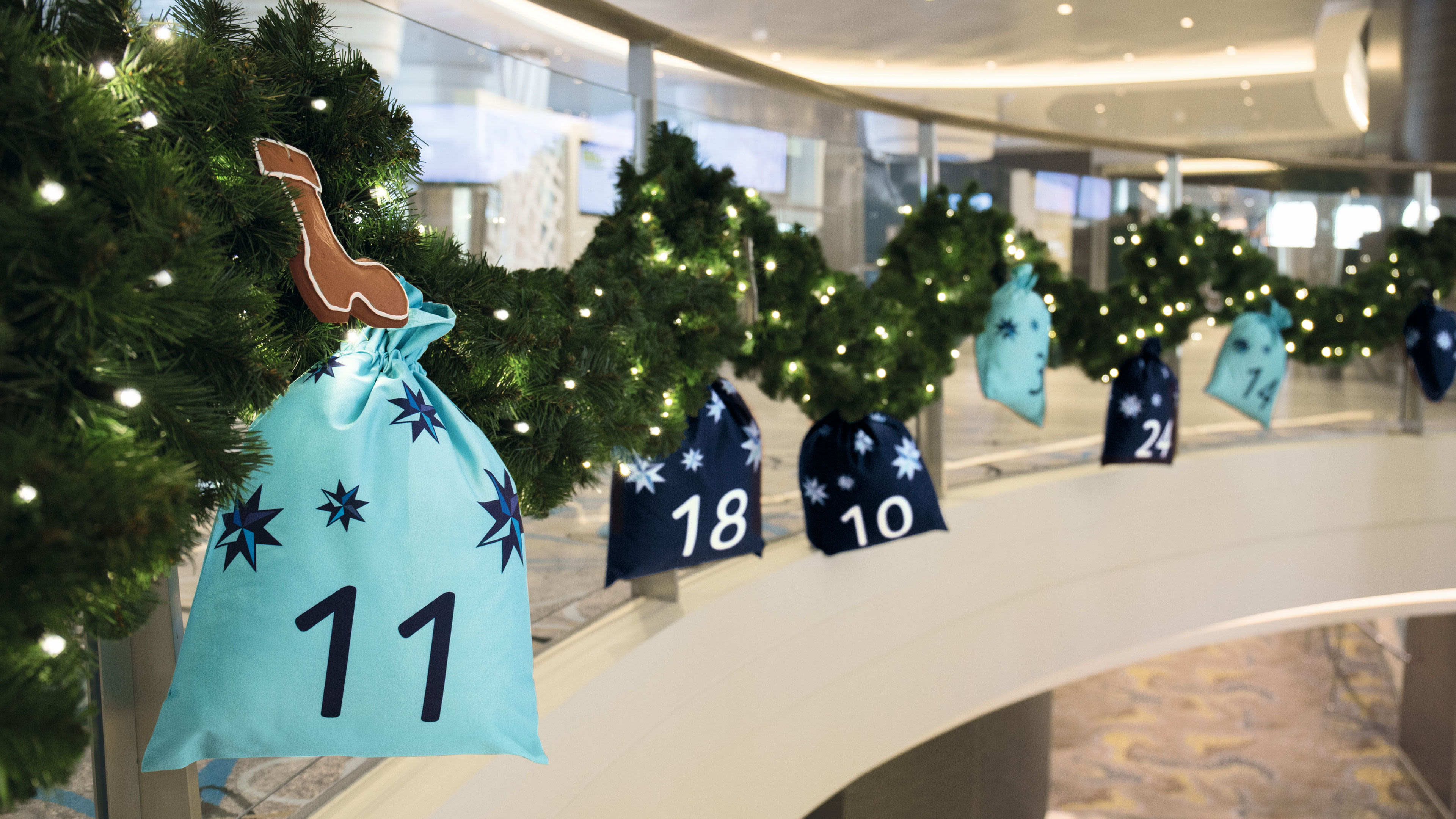 Weihnachtliche Girlande mit nummerierten Geschenksäcken und Lichtern.