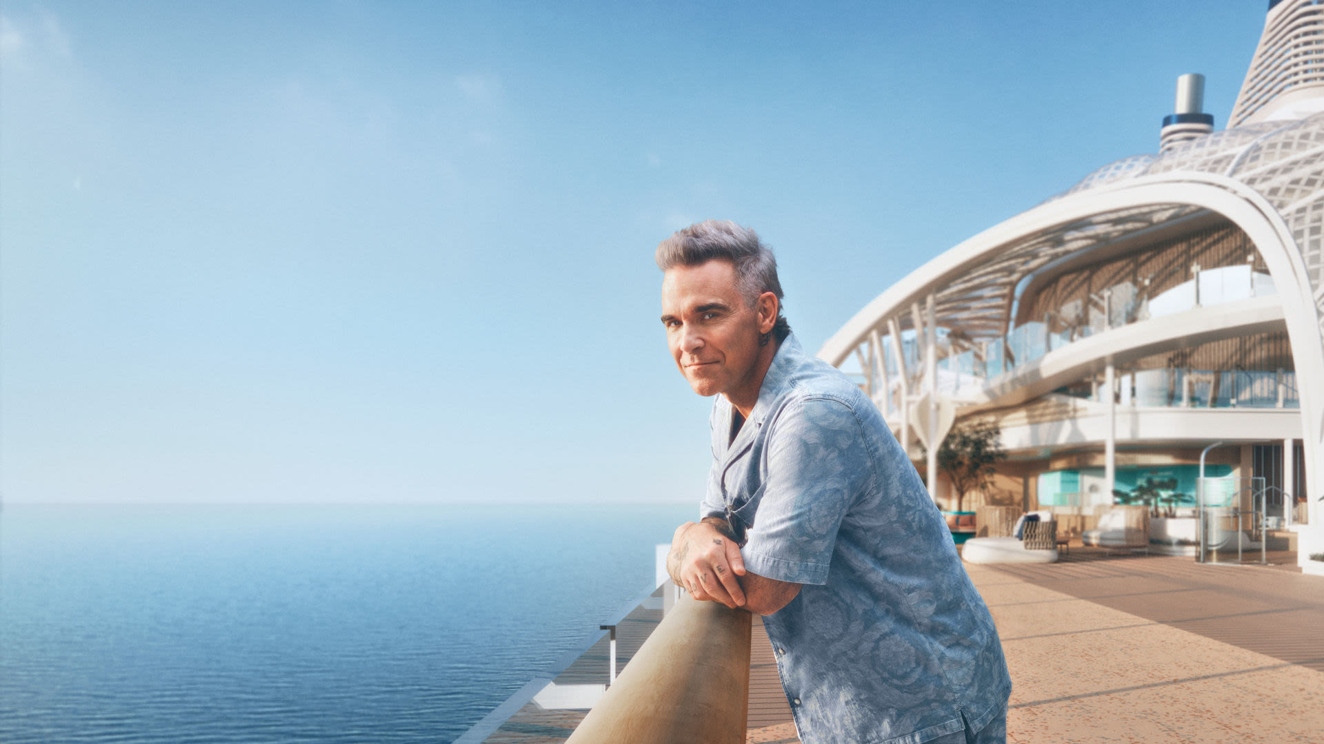 Mann lehnt am Geländer auf Kreuzfahrtschiff der Mein Schiff® Flotte, Meerblick.