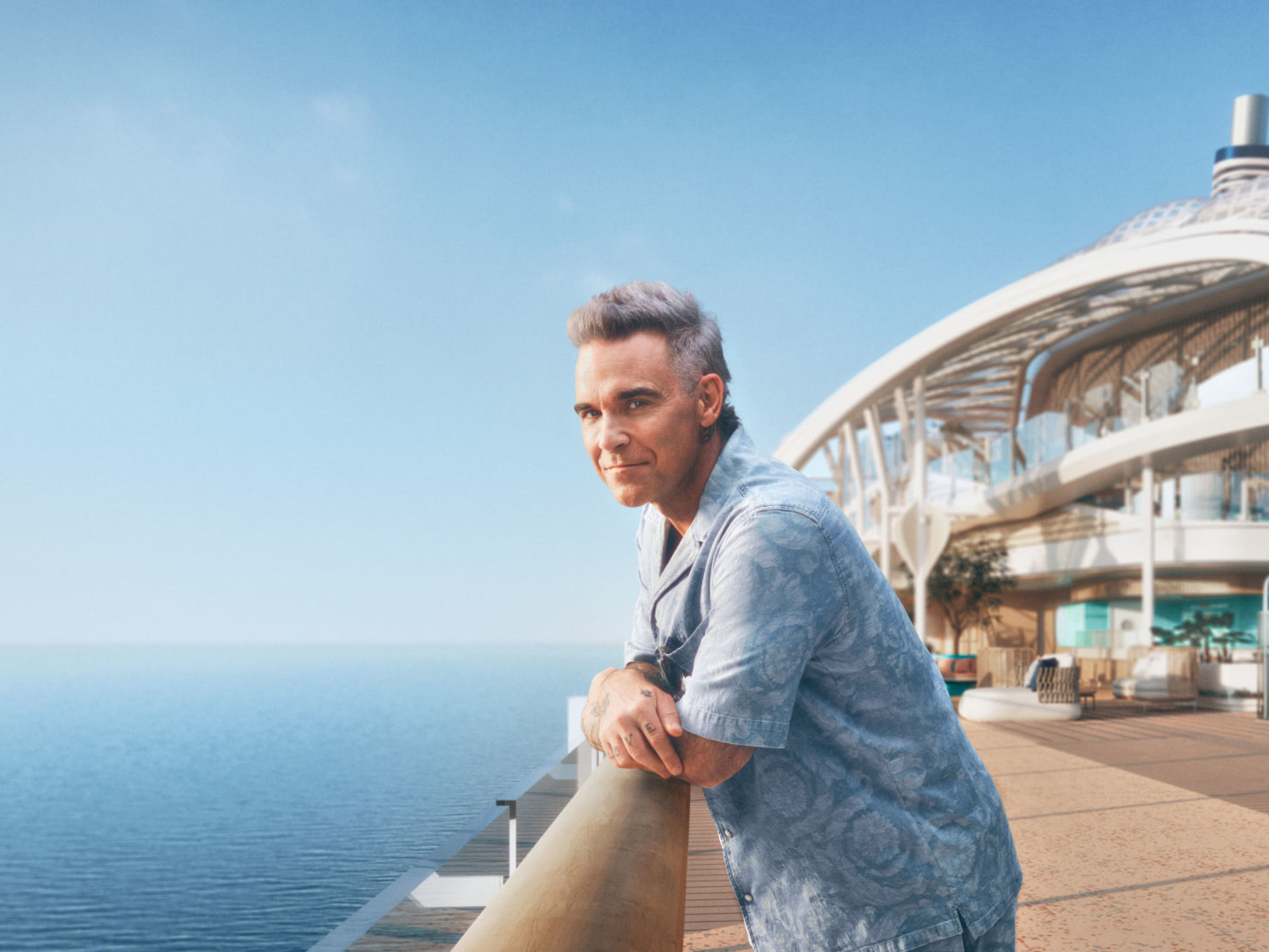 Robbie Williams - Mein Schiff Relax Mann lehnt am Geländer auf Kreuzfahrtschiff der Mein Schiff® Flotte, Meerblick.