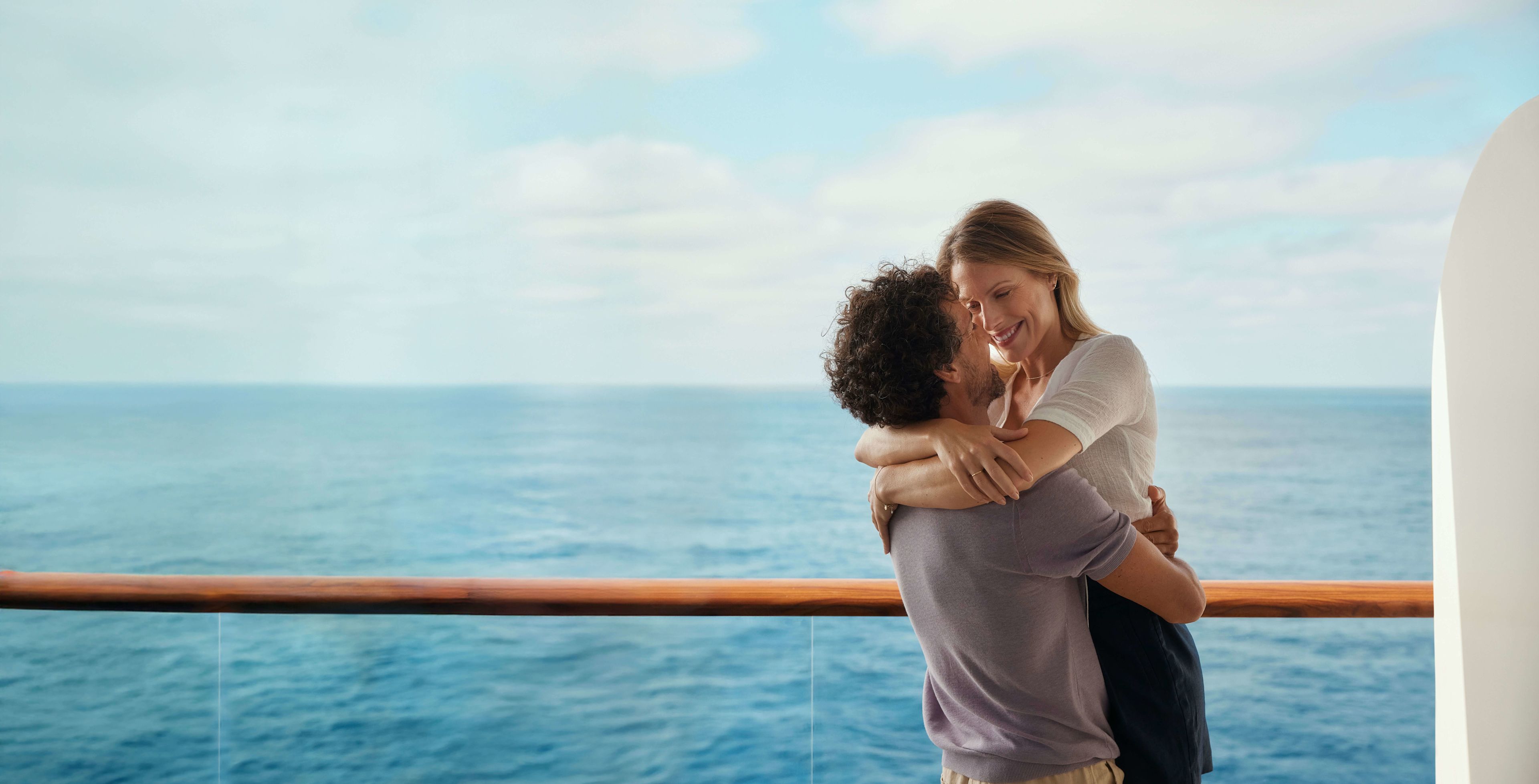 Paar umarmt sich auf Kreuzfahrtschiff, Meer im Hintergrund. Paar umarmt sich auf Kreuzfahrtschiff, Meer im Hintergrund.