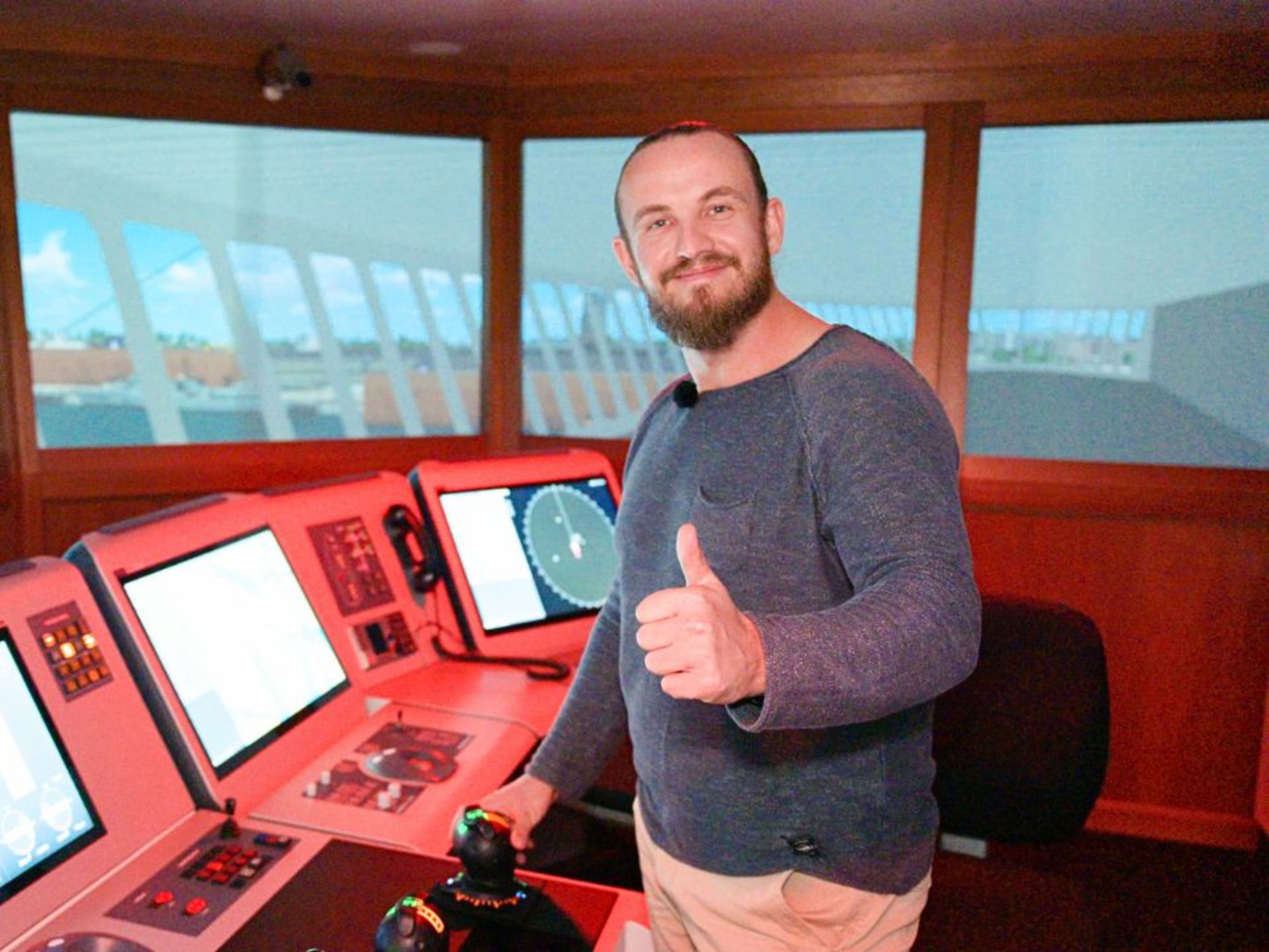 Jan Fortun Mann im Schiffssteuerraum mit Daumen hoch, lächelnd.