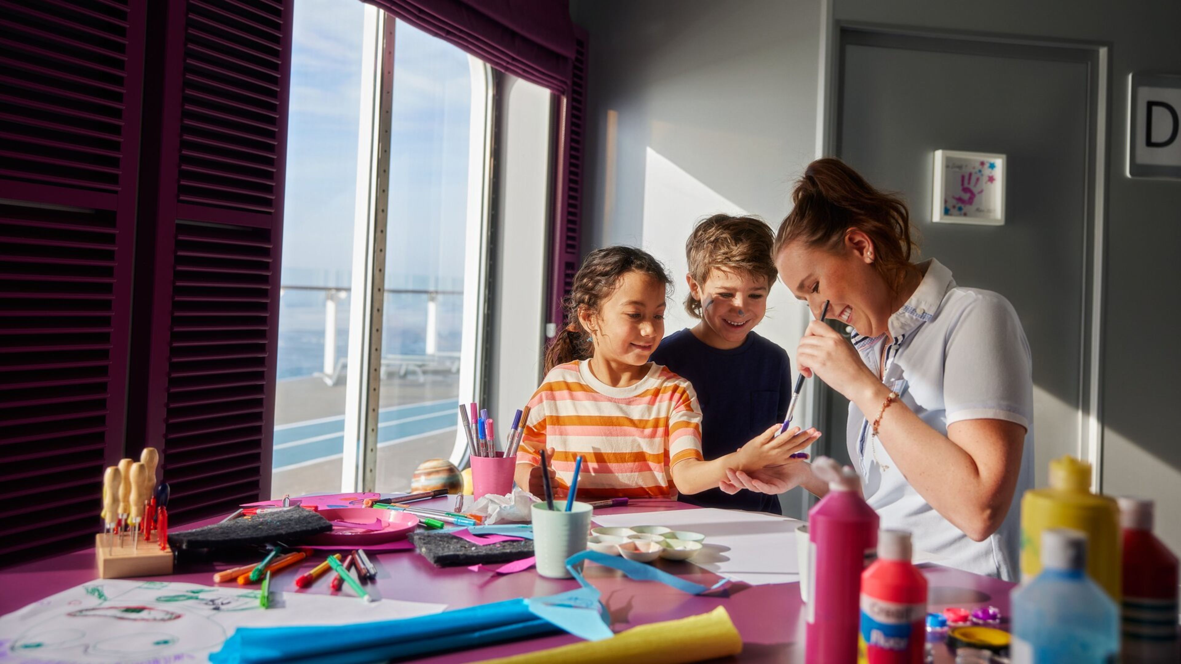 Kinder basteln mit Betreuerin auf Kreuzfahrtschiff der Mein Schiff® Flotte. Kinder basteln mit Betreuerin auf Kreuzfahrtschiff der Mein Schiff® Flotte.