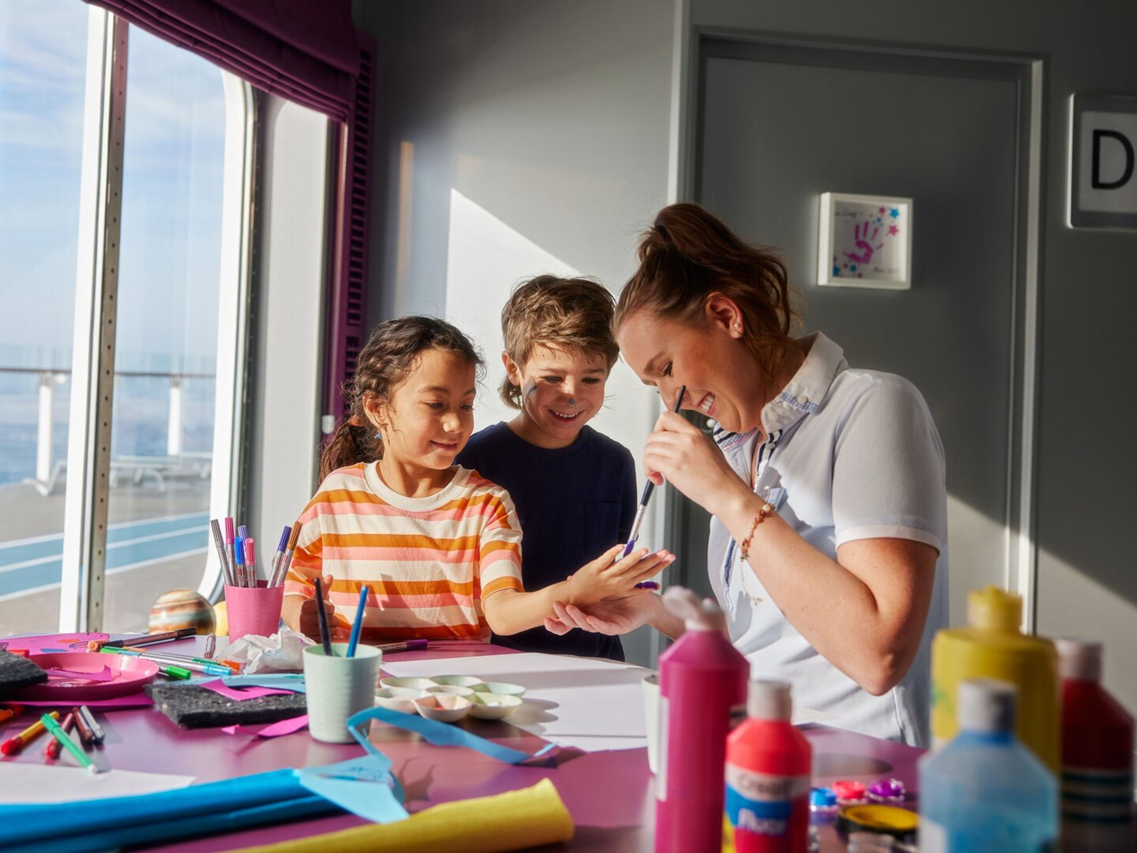 Familienreisen Kinder basteln mit Betreuerin auf Kreuzfahrtschiff der Mein Schiff® Flotte.
