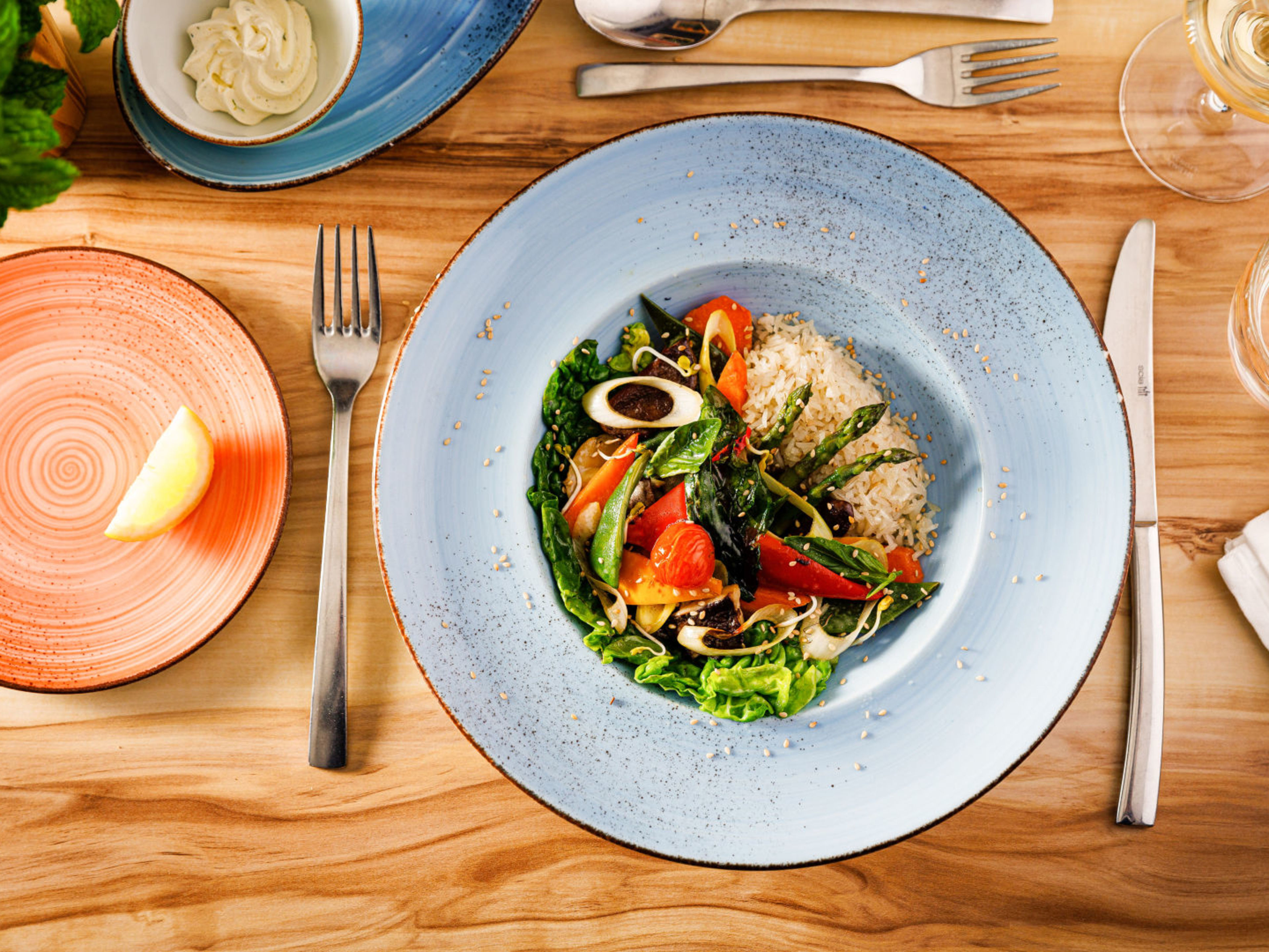 Fisch mit Salat - F&B Shooting Bunter Salat mit Reis auf blauem Teller, Holztisch.