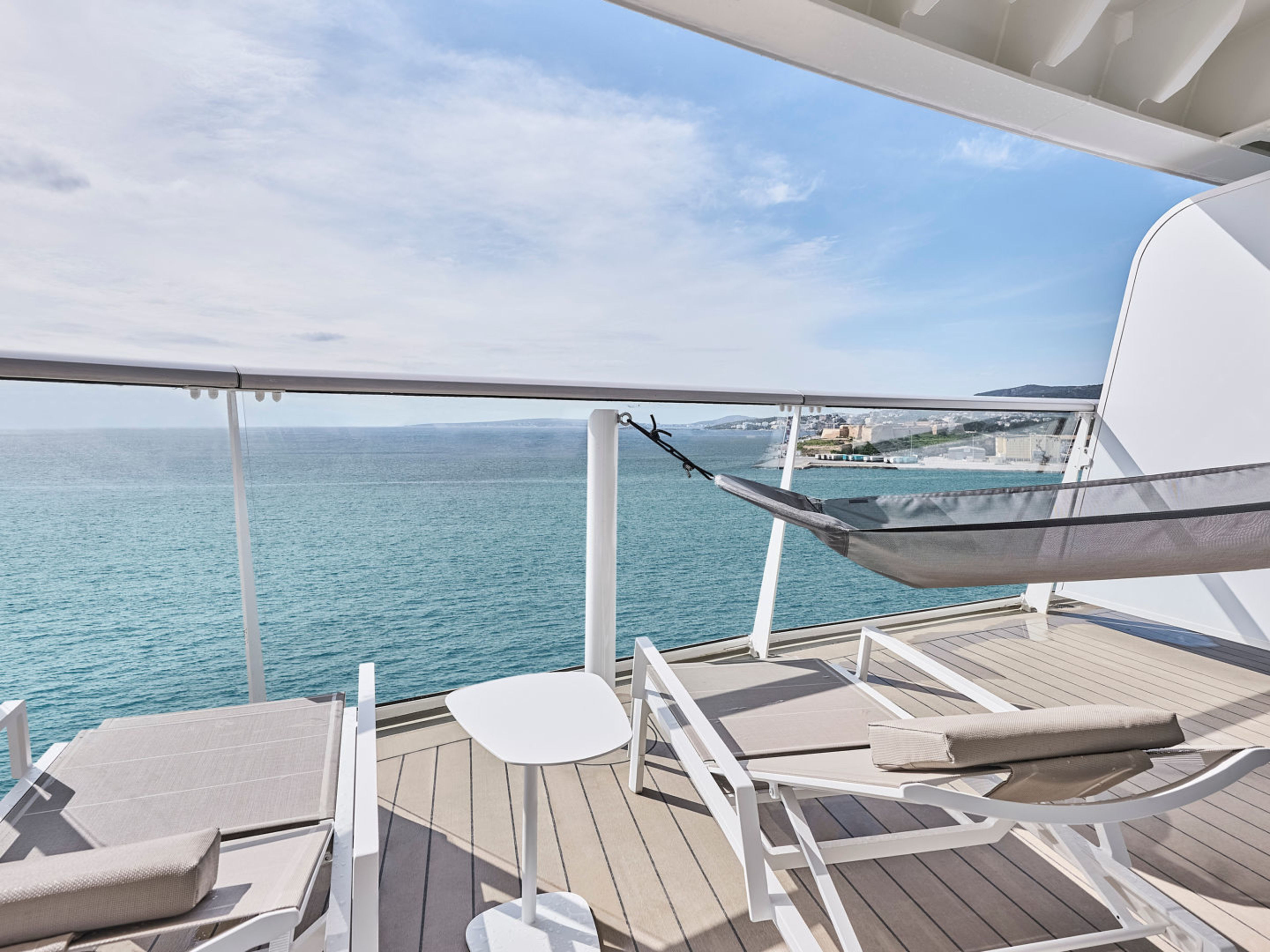 Balkon mit Liegestühlen und Hängematte auf Kreuzfahrtschiff, Meerblick. Balkon mit Liegestühlen und Hängematte auf Kreuzfahrtschiff, Meerblick.