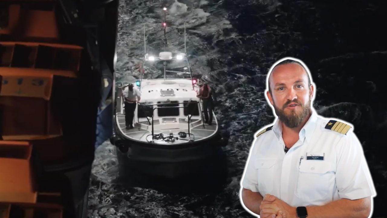 Mann in Uniform vor Boot auf stürmischer See.