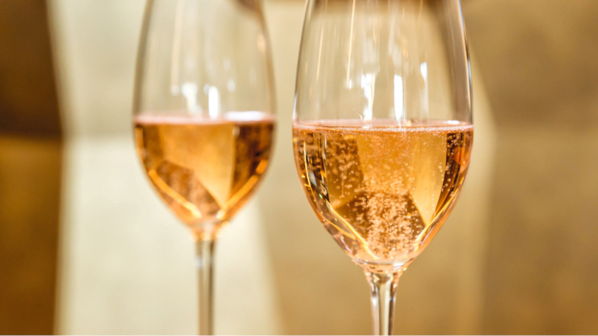Zwei Gläser Rosé-Sekt mit sprudelnden Bläschen.
