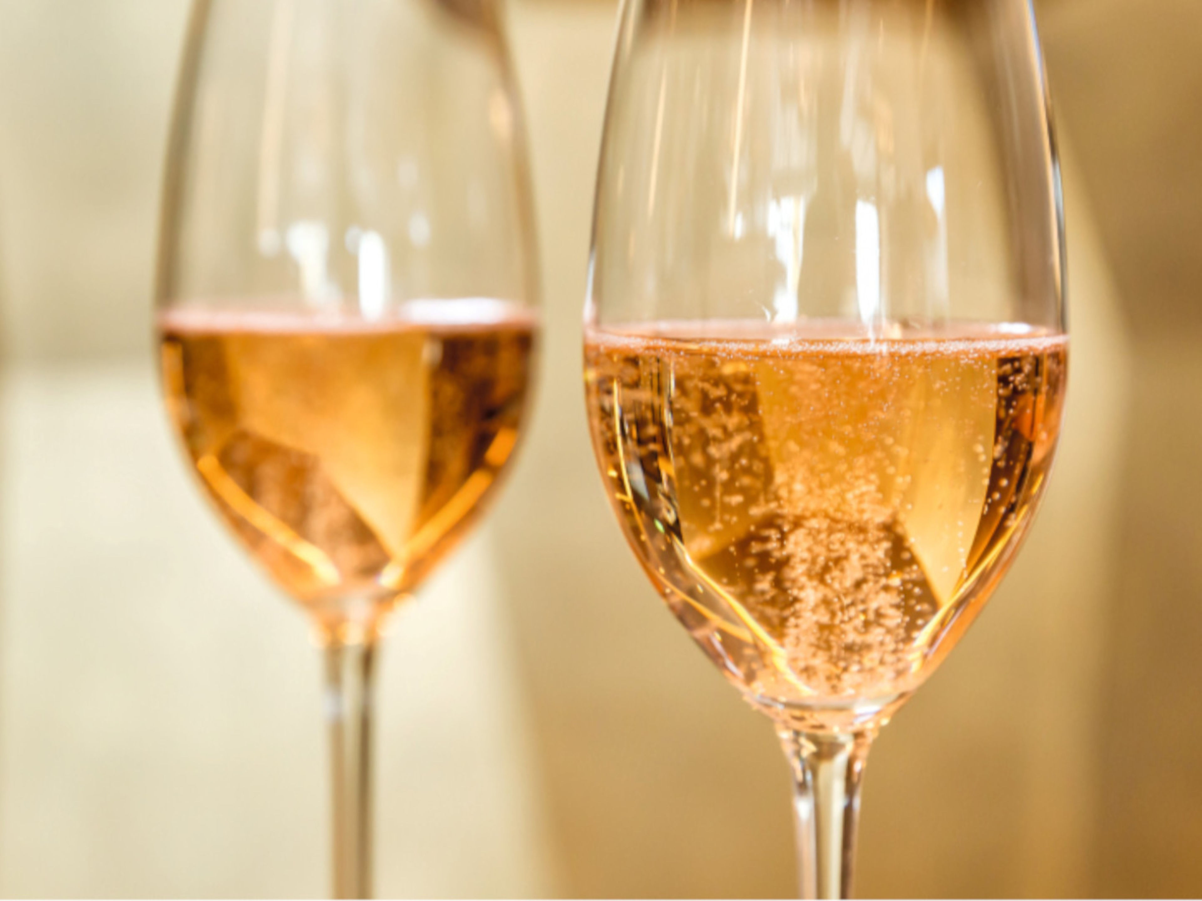 Champagner Zwei Gläser Rosé-Sekt mit sprudelnden Bläschen.