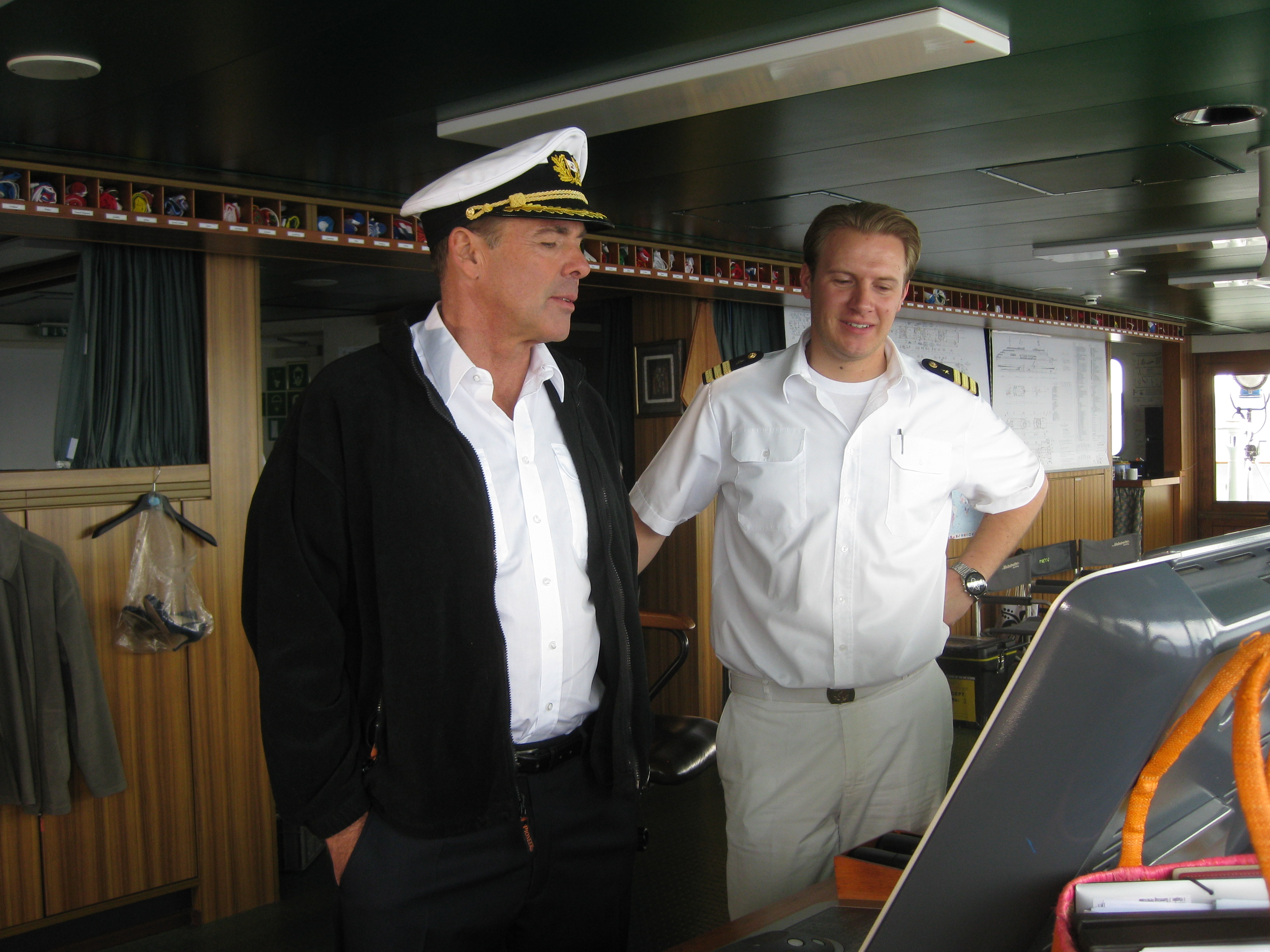 Zwei Männer in Uniform auf der Brücke eines Kreuzfahrtschiffs.