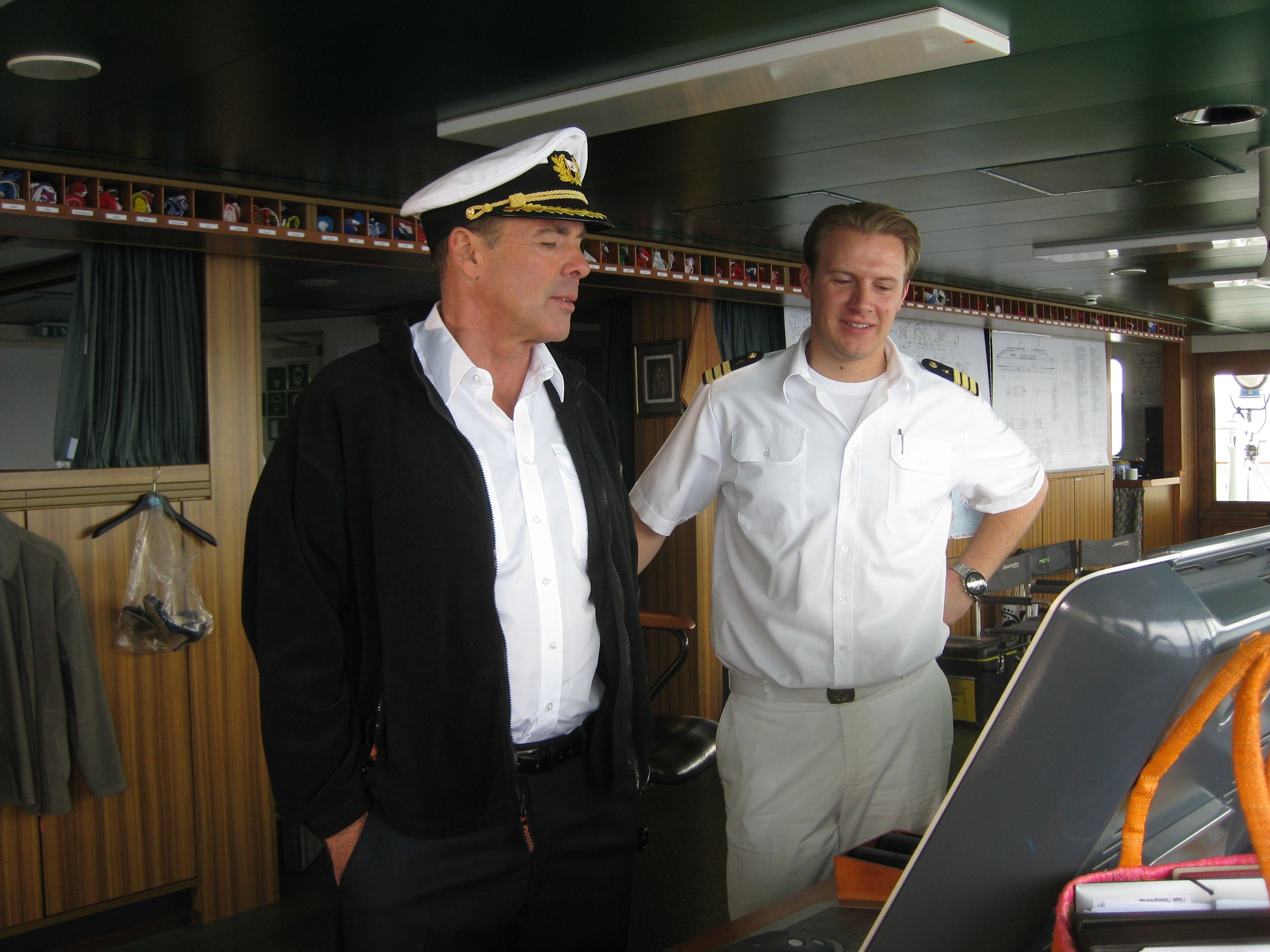 Zwei Männer in Uniform auf der Brücke eines Kreuzfahrtschiffs.