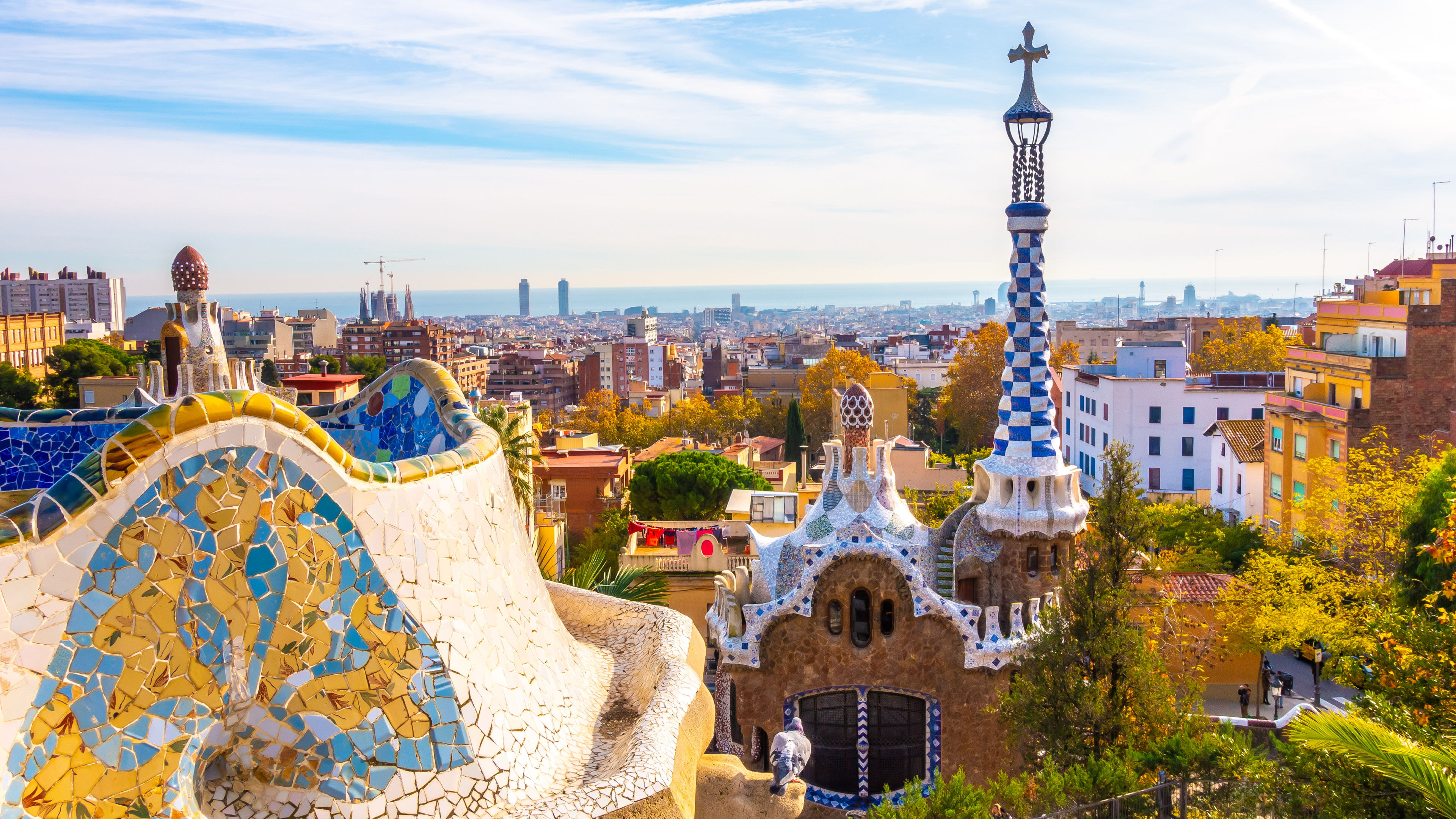 Park Güell in Barcelona mit Mosaiken und Stadtblick.