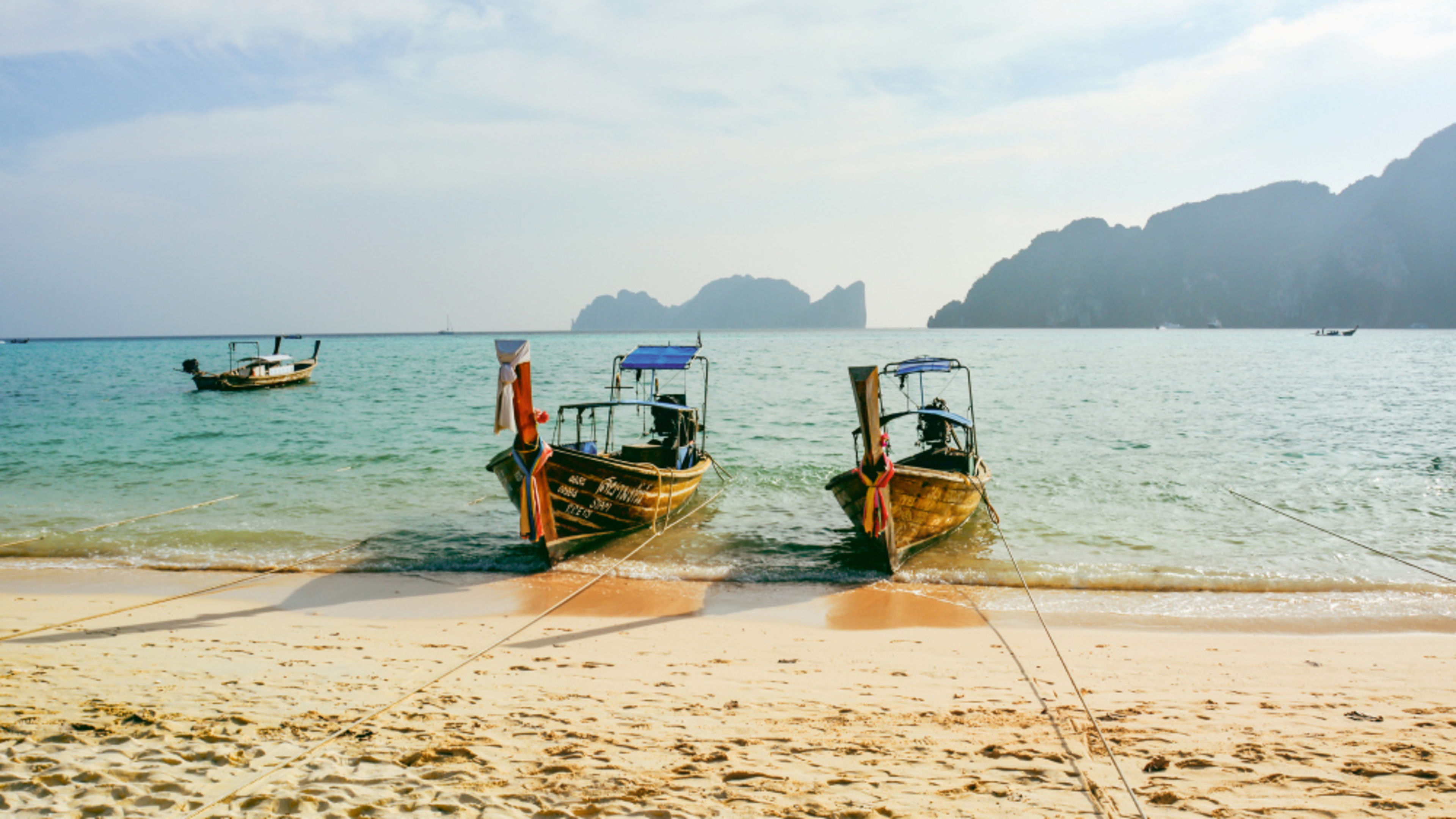 Zwei Longtail-Boote am Strand von Ko Phi Phi, Thailand. Zwei Longtail-Boote am Strand von Ko Phi Phi, Thailand.