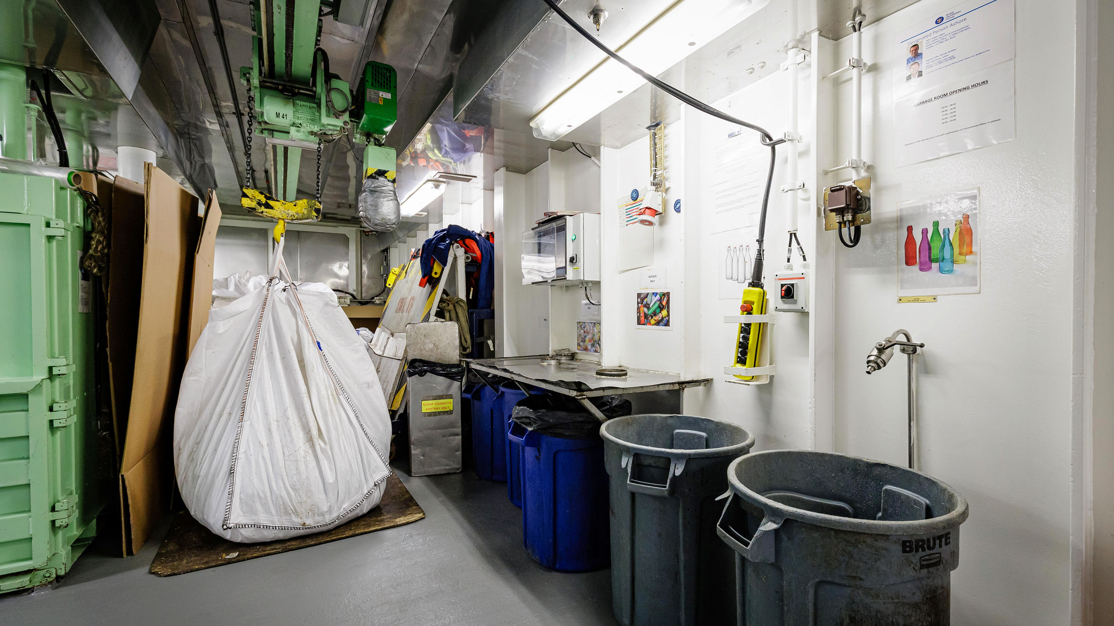 Industrieller Raum mit Mülltonnen und Recyclingmaterial.