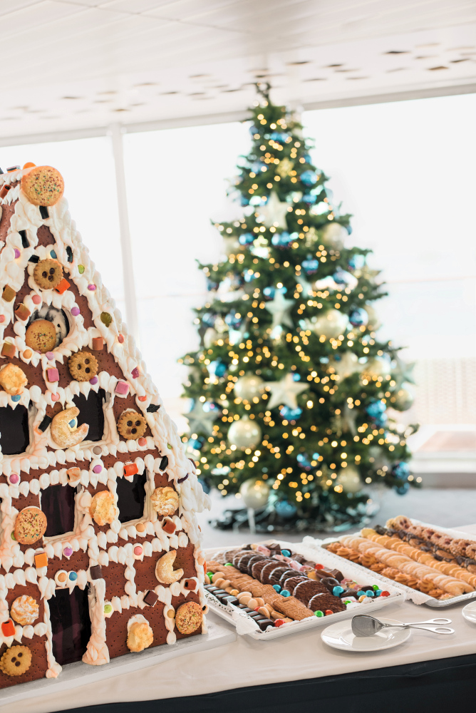 Lebkuchenhaus und Weihnachtsbaum mit Lichtern und Keksen.