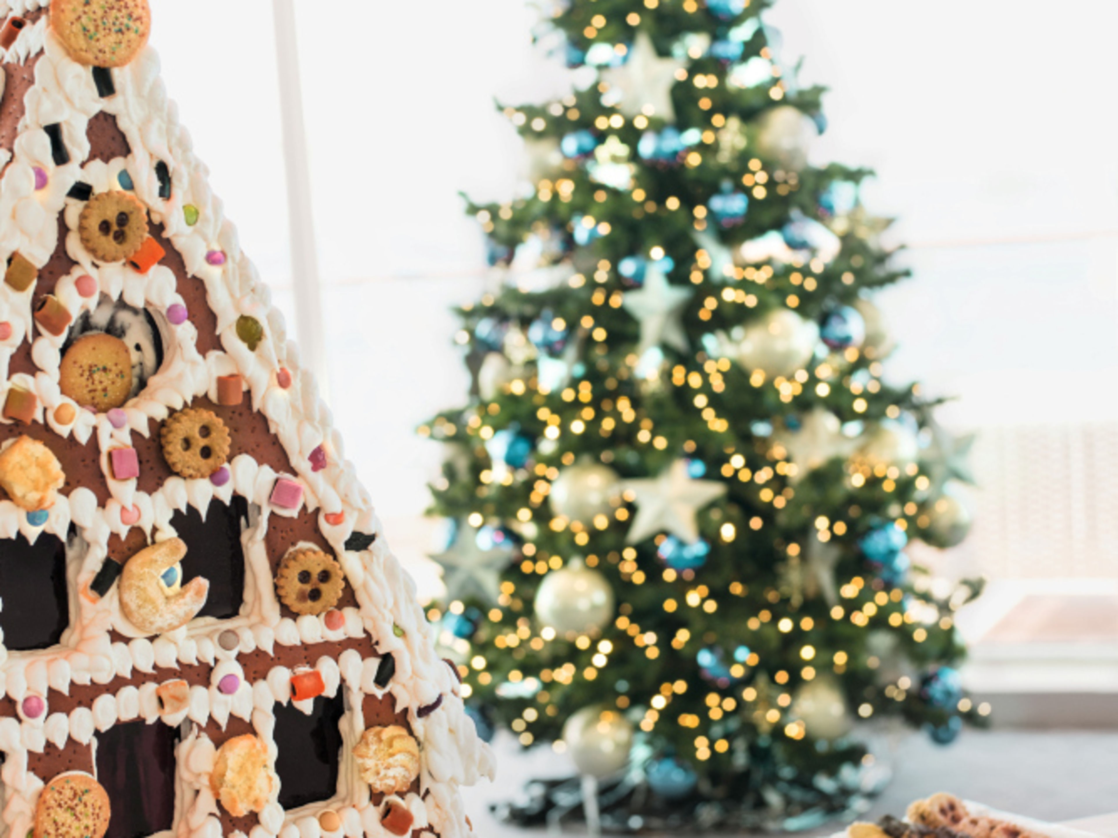 Lebkuchenhaus und Weihnachtsbaum mit Lichtern und Keksen. Lebkuchenhaus und Weihnachtsbaum mit Lichtern und Keksen.