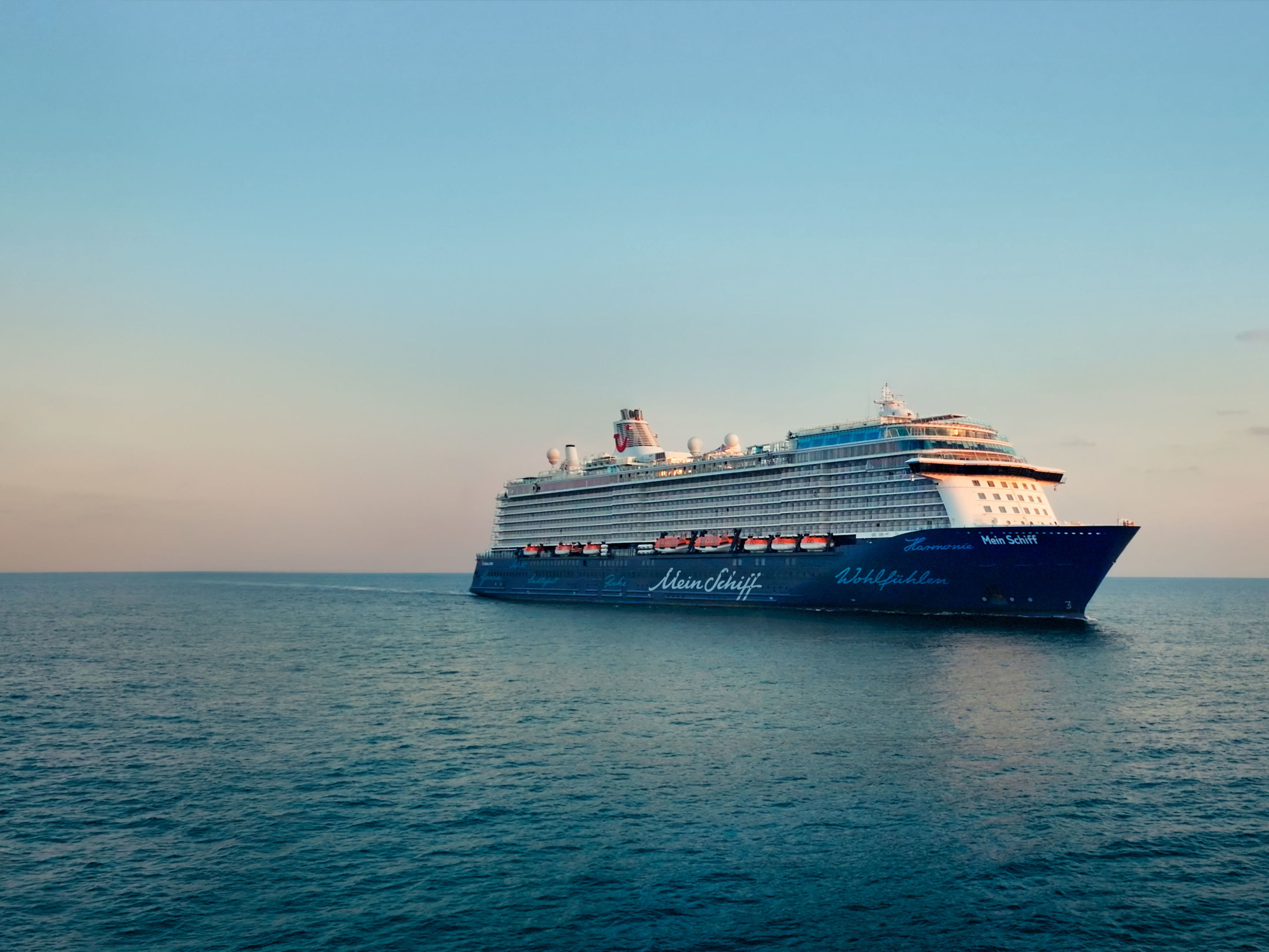 Kreuzfahrtschiff der Mein Schiff® Flotte auf offenem Meer bei Sonnenuntergang. Kreuzfahrtschiff der Mein Schiff® Flotte auf offenem Meer bei Sonnenuntergang.