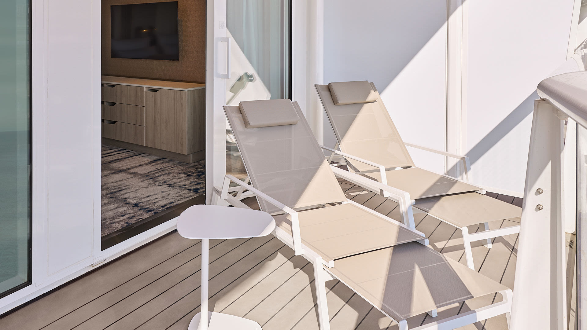 Zwei Liegestühle auf Balkon eines Kreuzfahrtschiffs der Mein Schiff® Flotte.