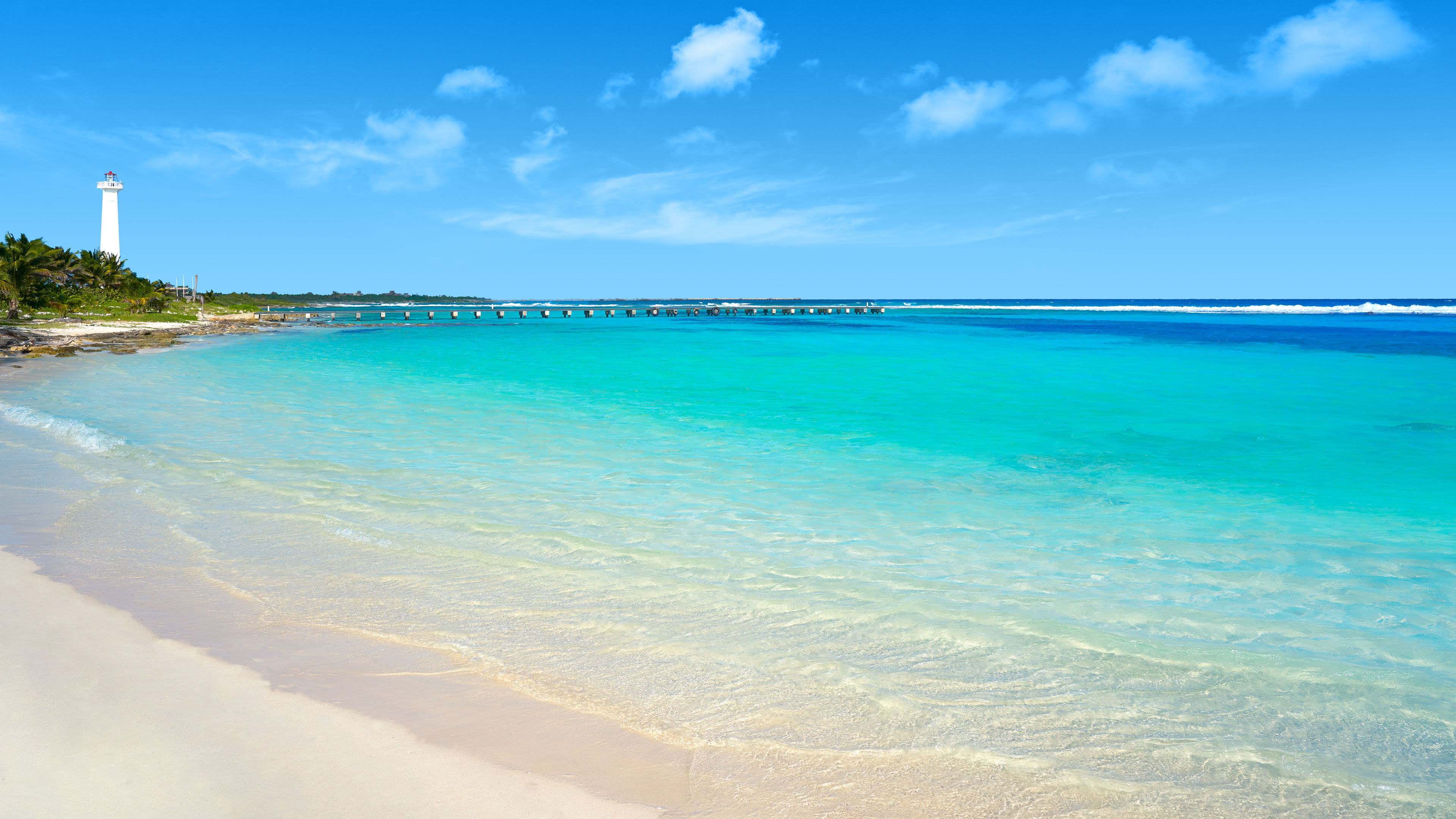 Costa Maya Mexiko Strand mit türkisfarbenem Wasser, Leuchtturm und blauem Himmel.