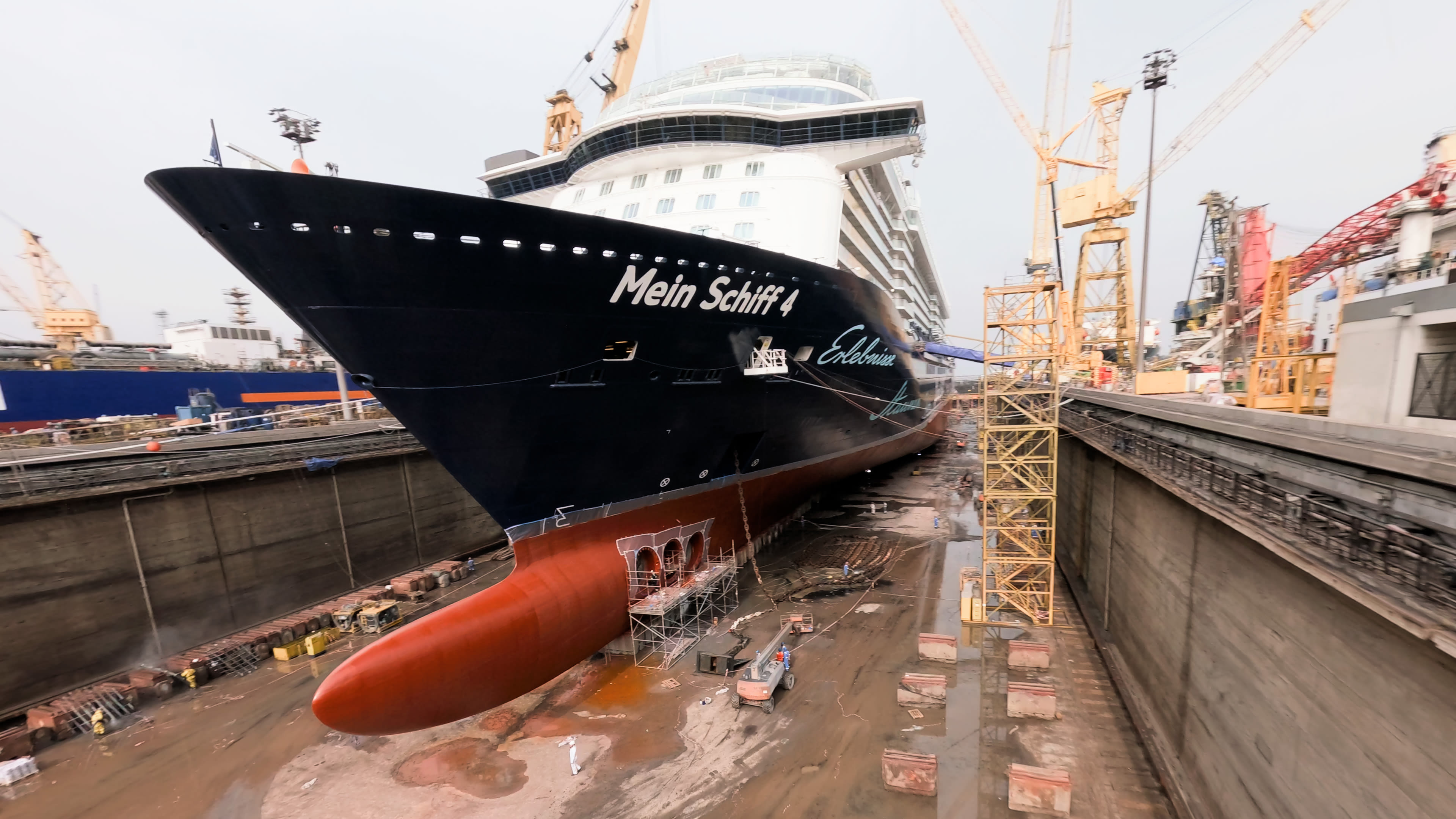 Kreuzfahrtschiff der Mein Schiff® Flotte im Trockendock, umgeben von Kränen.