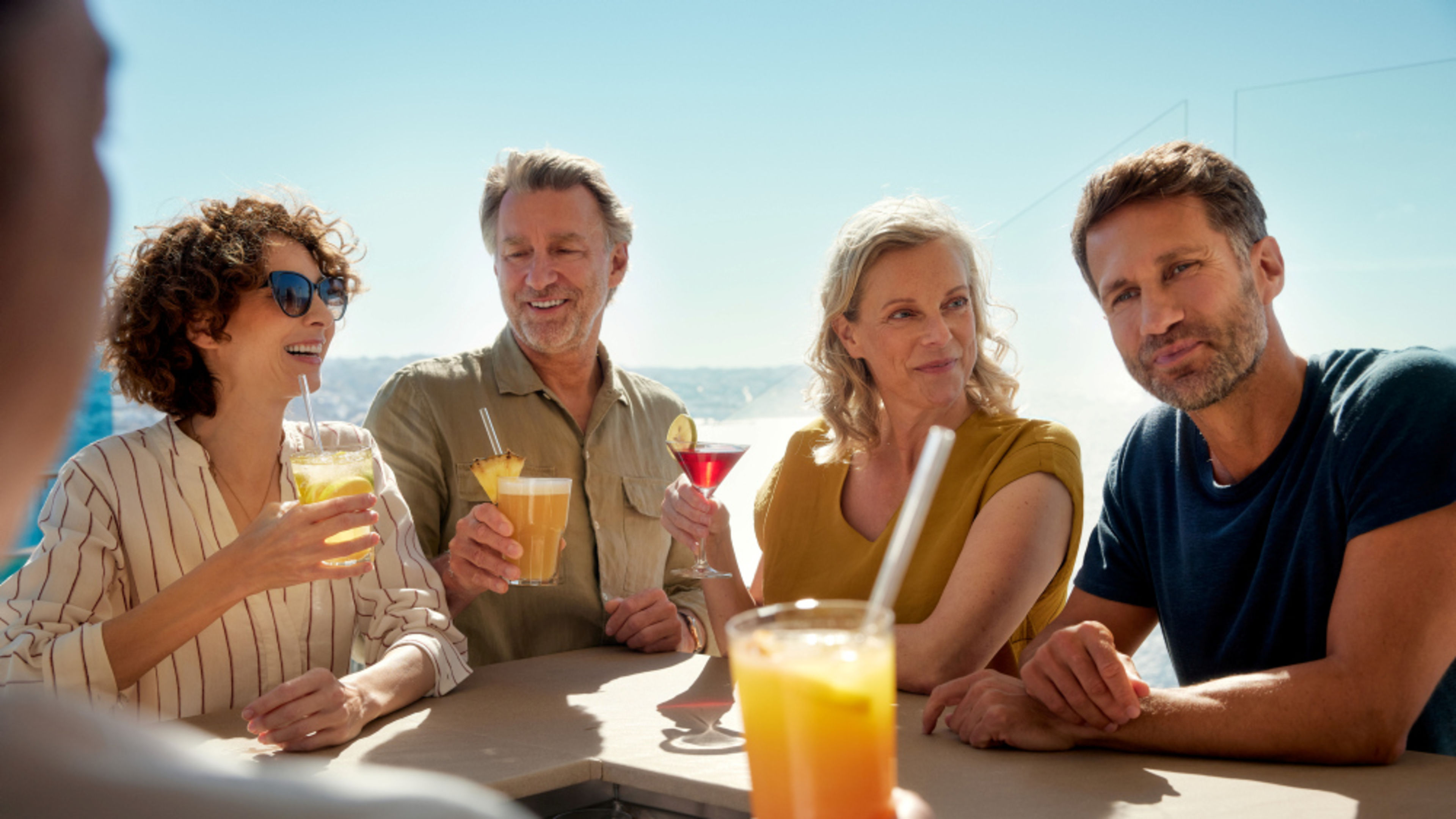 An der Bar Gruppe von Freunden genießt Cocktails an einer sonnigen Bar.