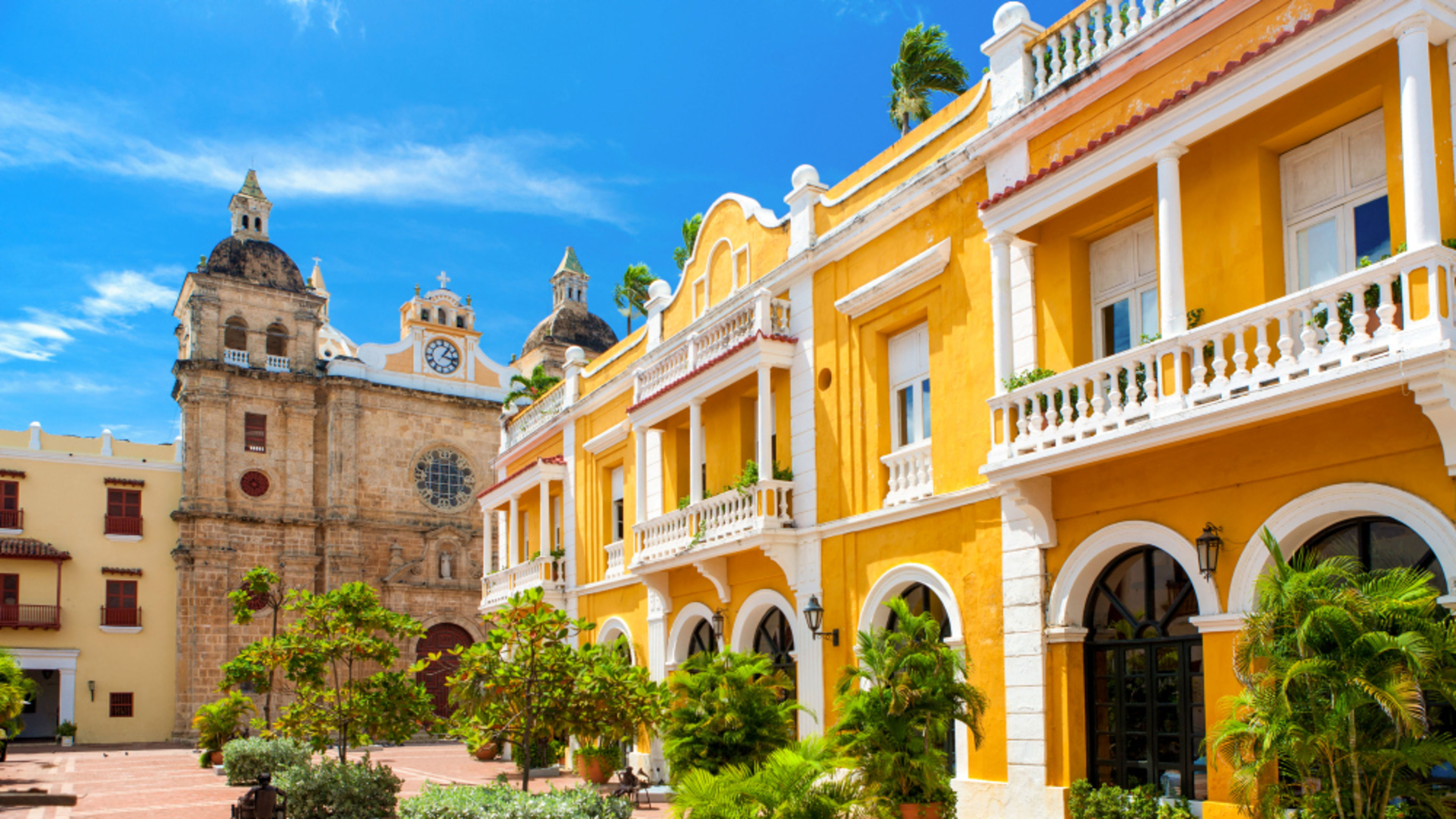 Mittelamerika Cartagena Kolumbien Gelbes Kolonialgebäude und Kirche in Cartagena, blauer Himmel.