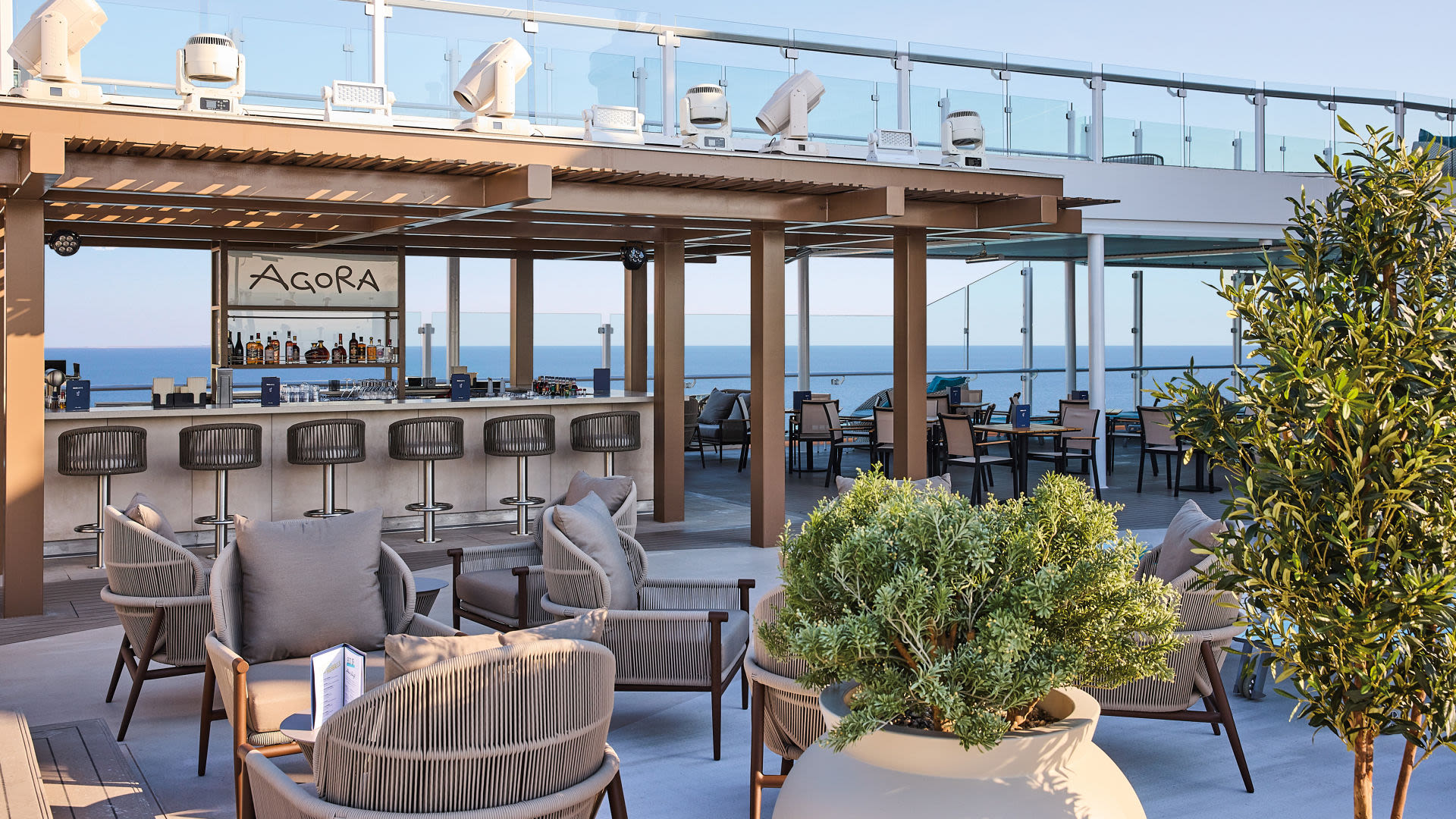 Offene Bar mit Meerblick, moderne Sitzgelegenheiten, Pflanzen.