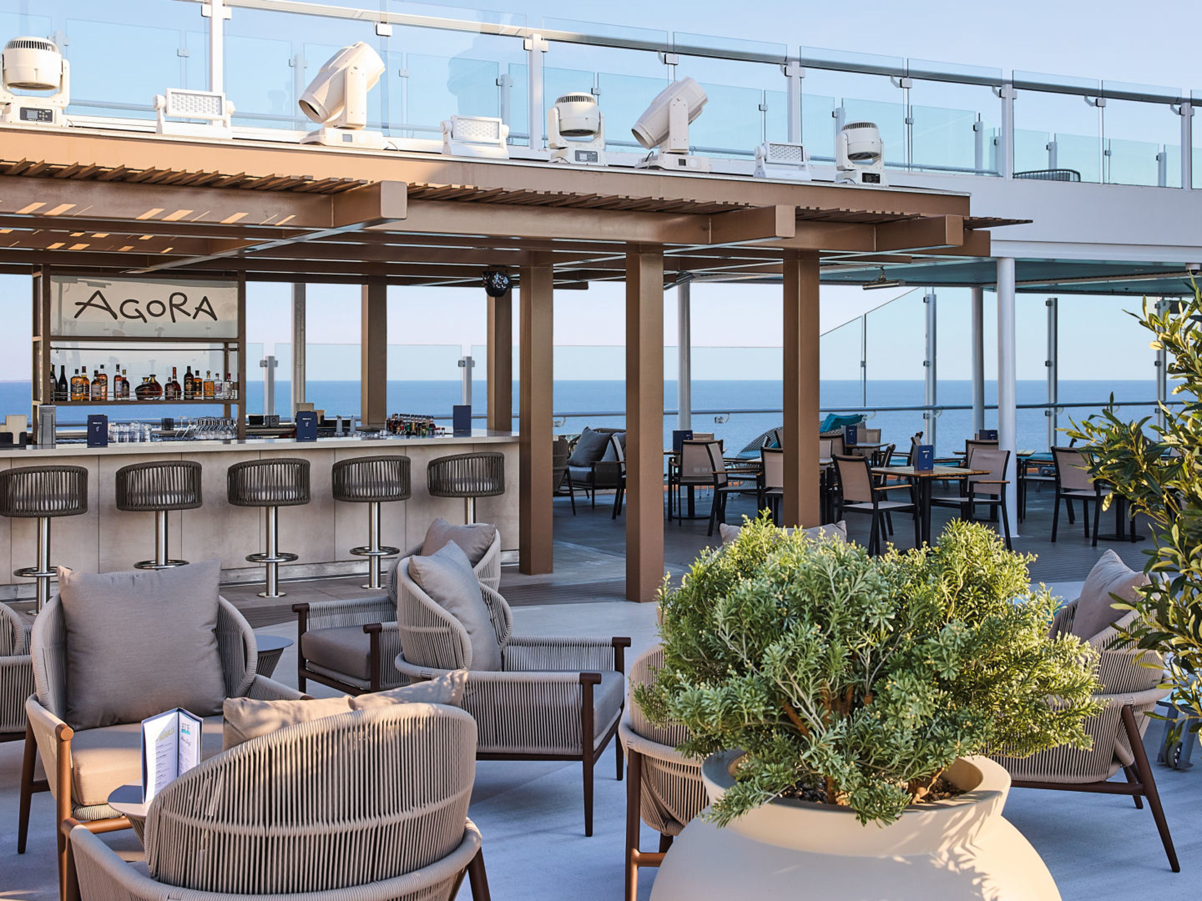 Agora Bar auf der Mein Schiff Relax Offene Bar mit Meerblick, moderne Sitzgelegenheiten, Pflanzen.