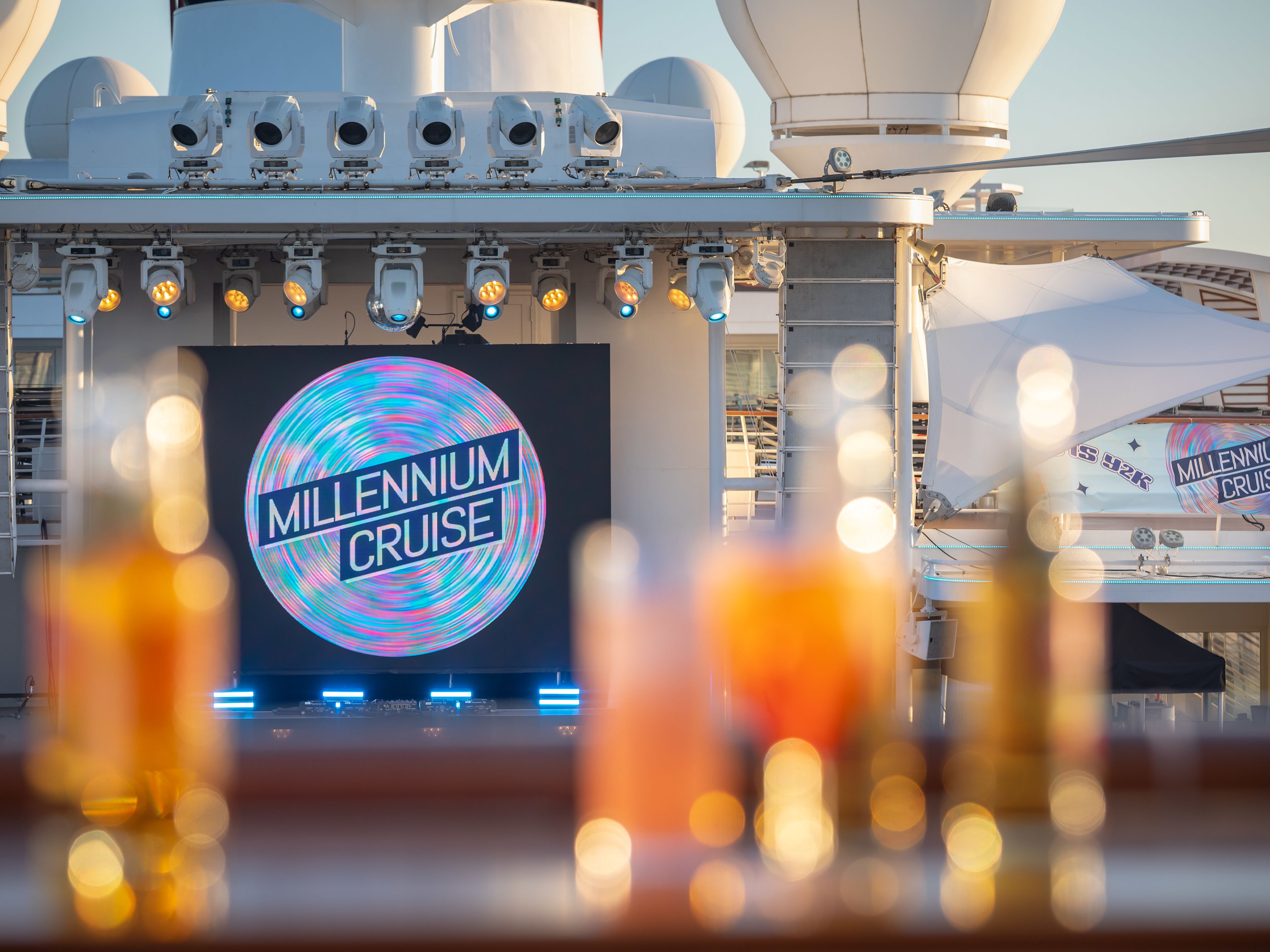 Mein Schiff Millenium Cruise Kreuzfahrtschiff-Deck mit Millennium Cruise-Logo und Getränken im Vordergrund.