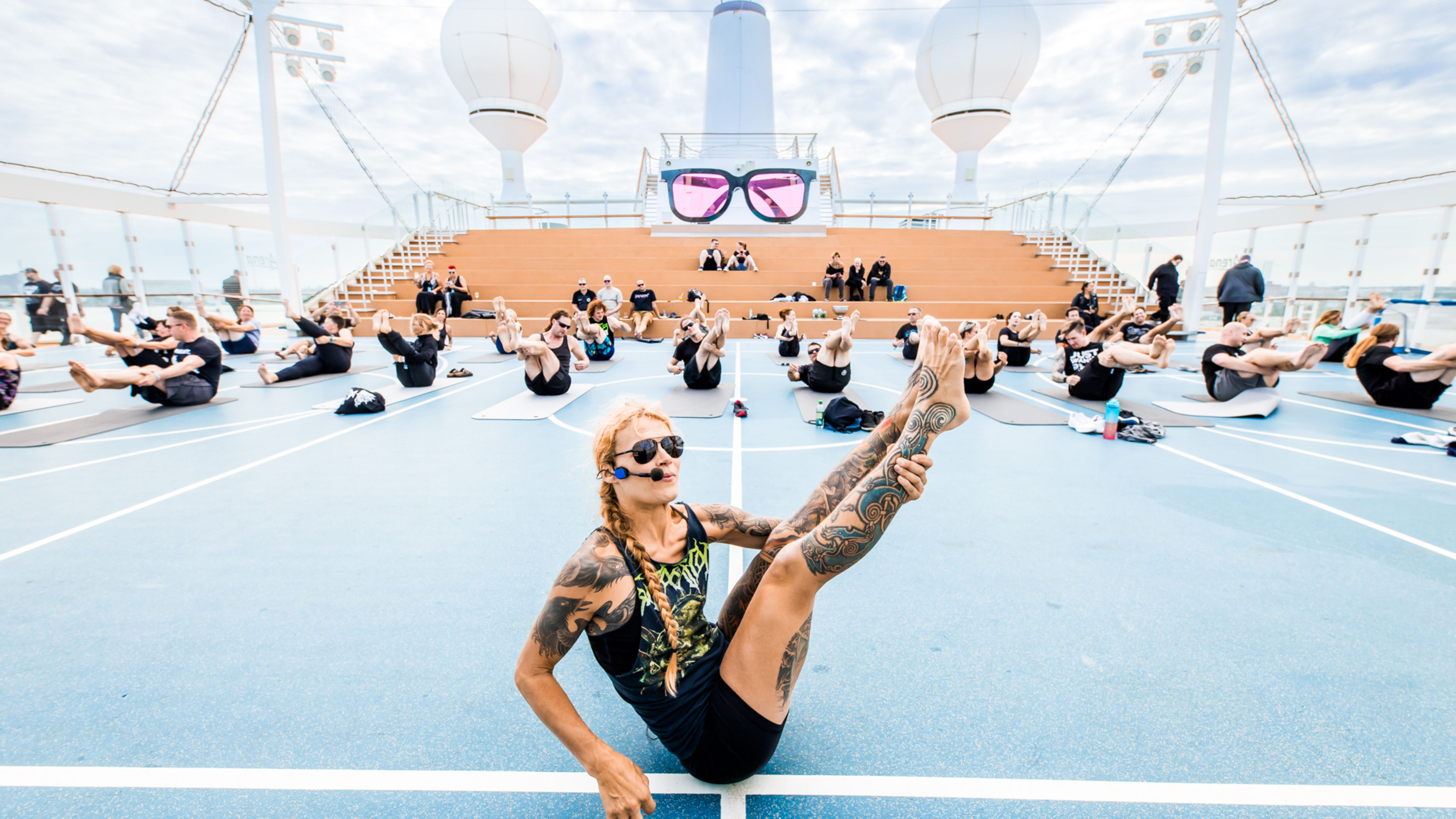Menschen machen Yoga auf Kreuzfahrtschiffdeck, blauer Himmel, Sonnenbrillen. Menschen machen Yoga auf Kreuzfahrtschiffdeck, blauer Himmel, Sonnenbrillen.