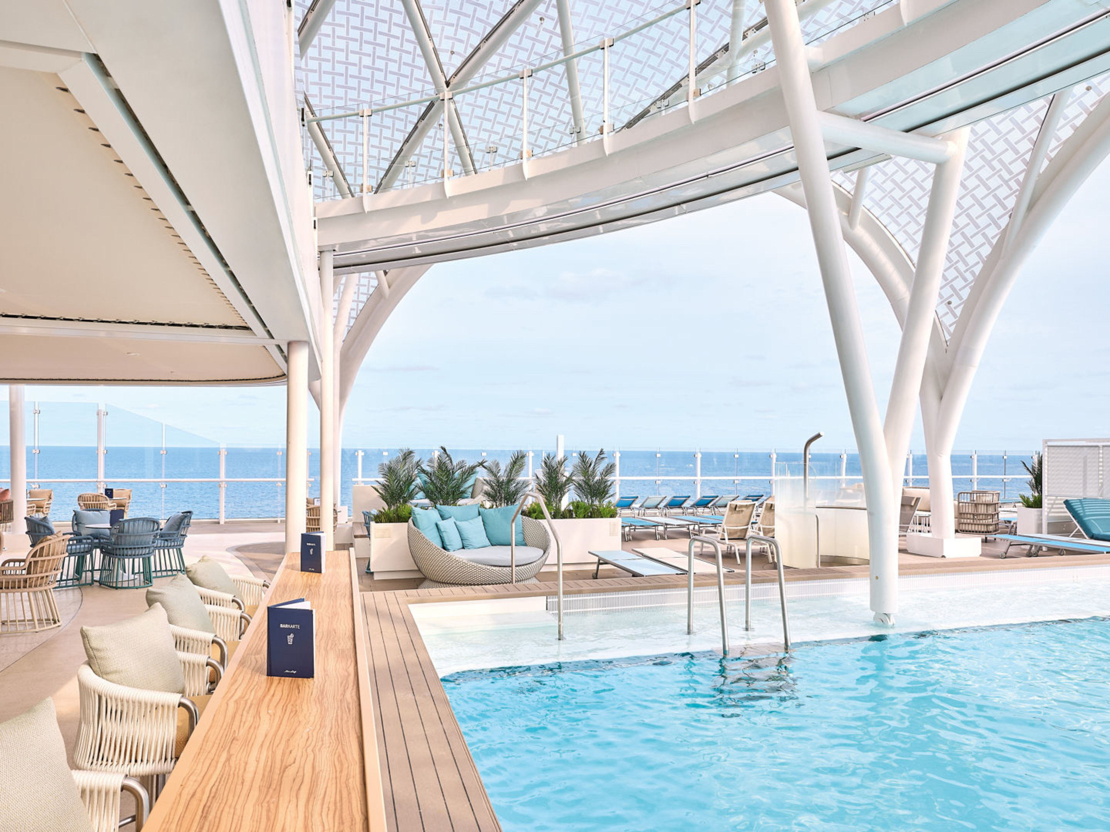 Pooldeck auf Kreuzfahrtschiff mit Meerblick, moderne Möbel, helle Farben. Pooldeck auf Kreuzfahrtschiff mit Meerblick, moderne Möbel, helle Farben.