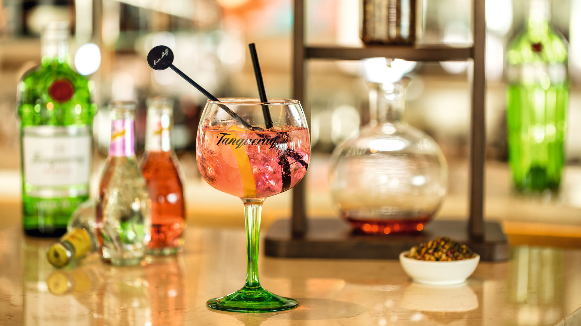 Cocktailglas mit rosa Getränk, Zitronenscheibe, Barhintergrund.