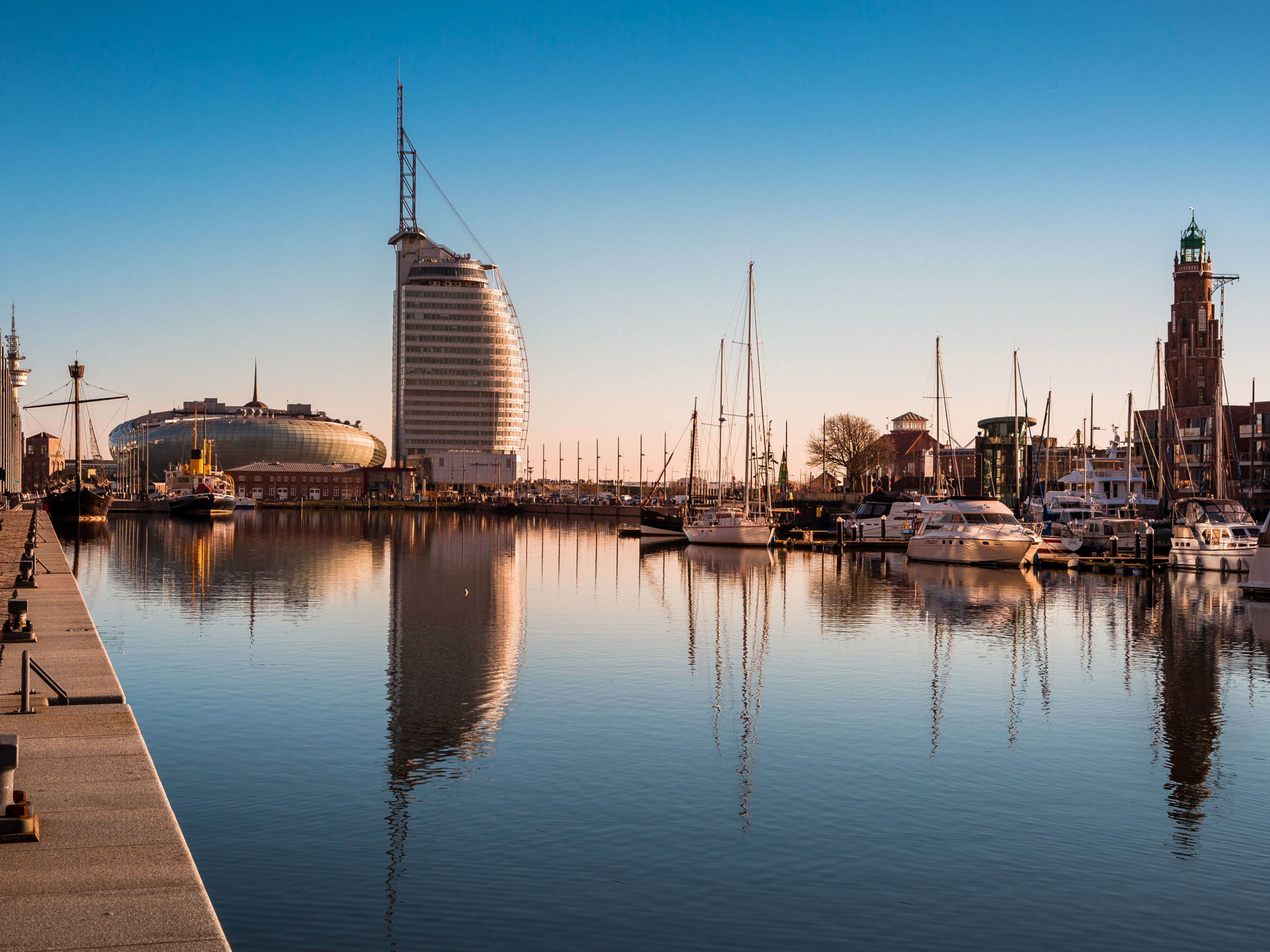 Bremerhaven Bremerhaven Hafen mit Segelbooten, modernem Gebäude und klarem Himmel.