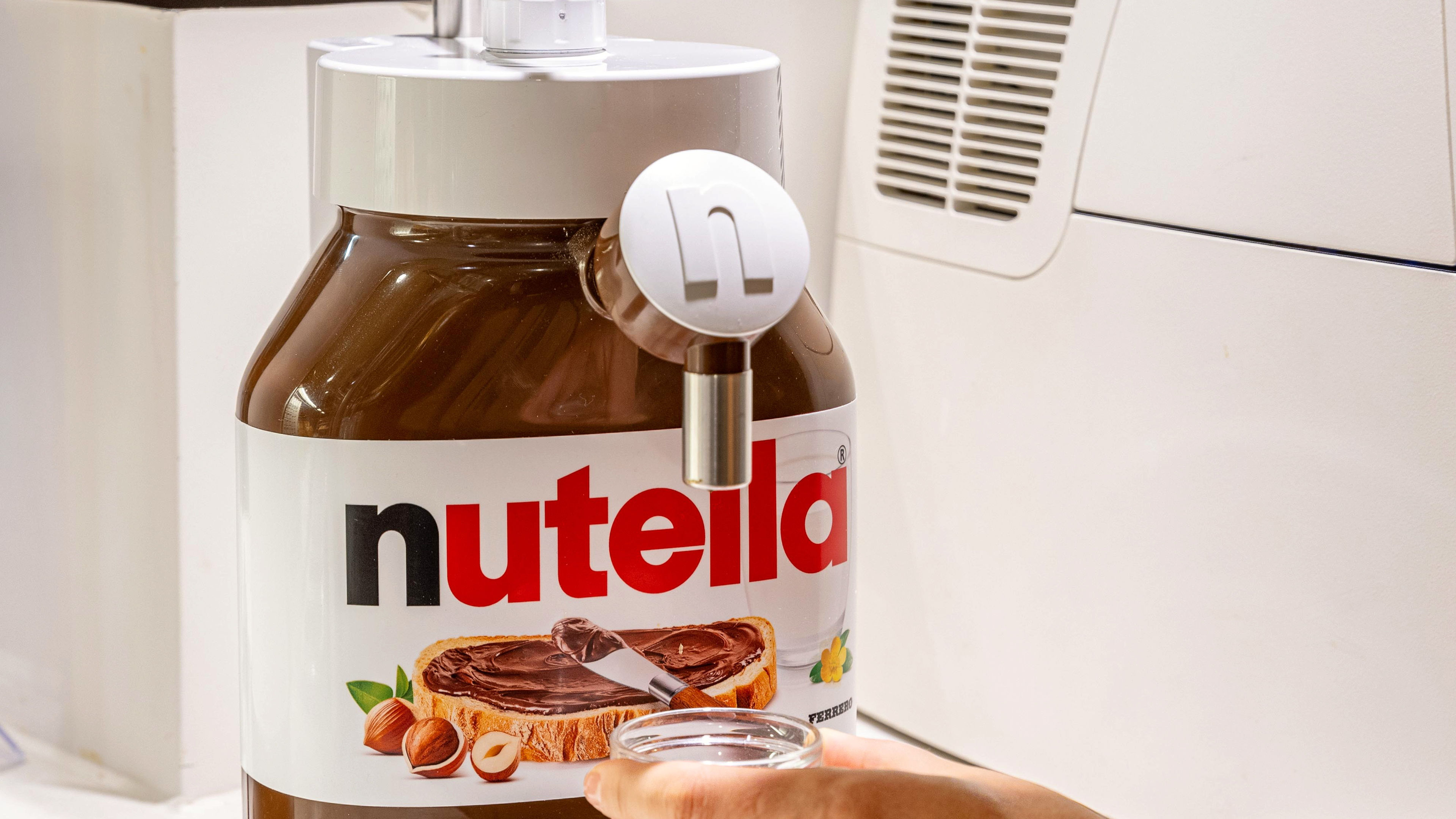 Nutella-Spender mit Glas, weiße und braune Farben.