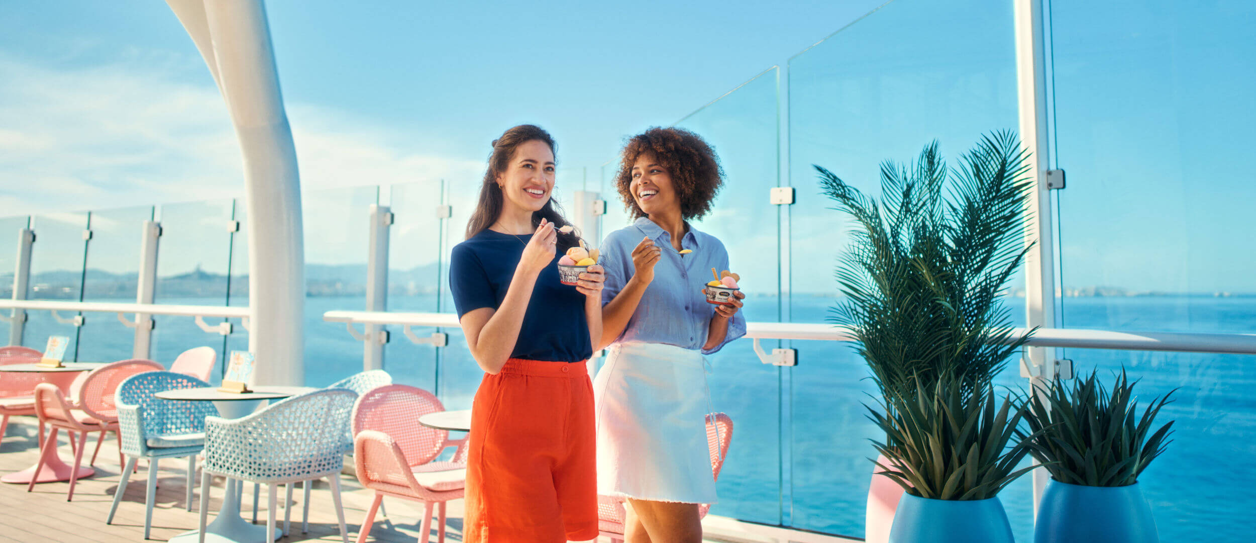 Zwei Frauen essen Eis auf Kreuzfahrtschiff der Mein Schiff® Flotte, sonniger Tag.