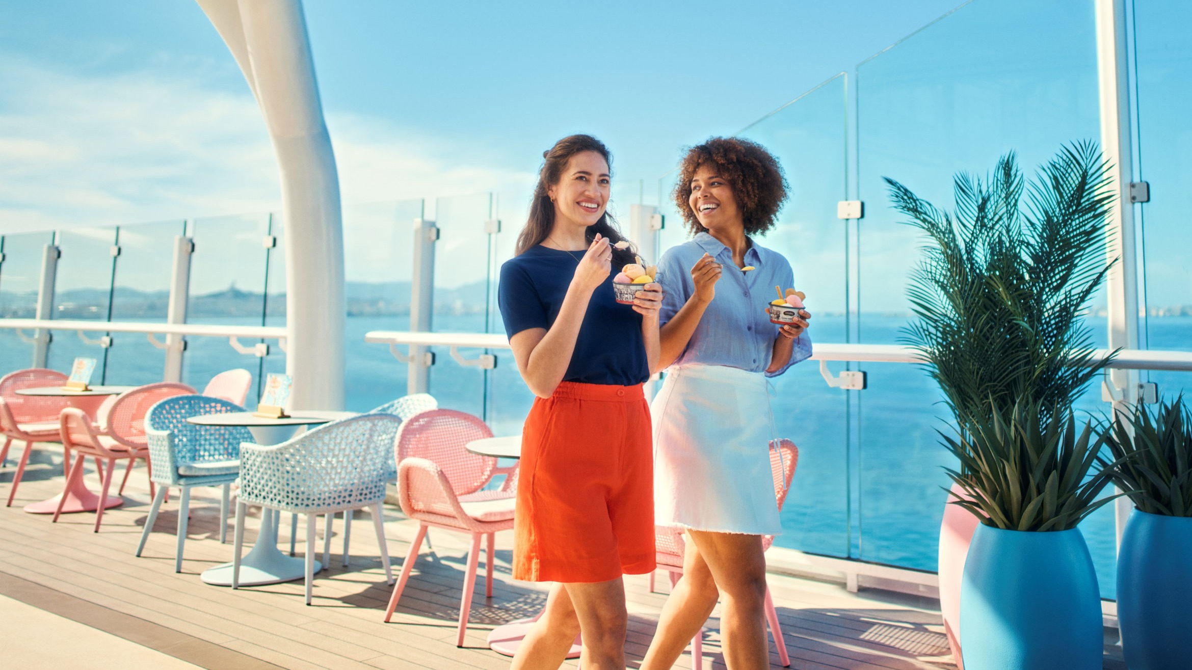 Zwei Frauen essen Eis auf Kreuzfahrtschiff der Mein Schiff® Flotte, sonniger Tag.