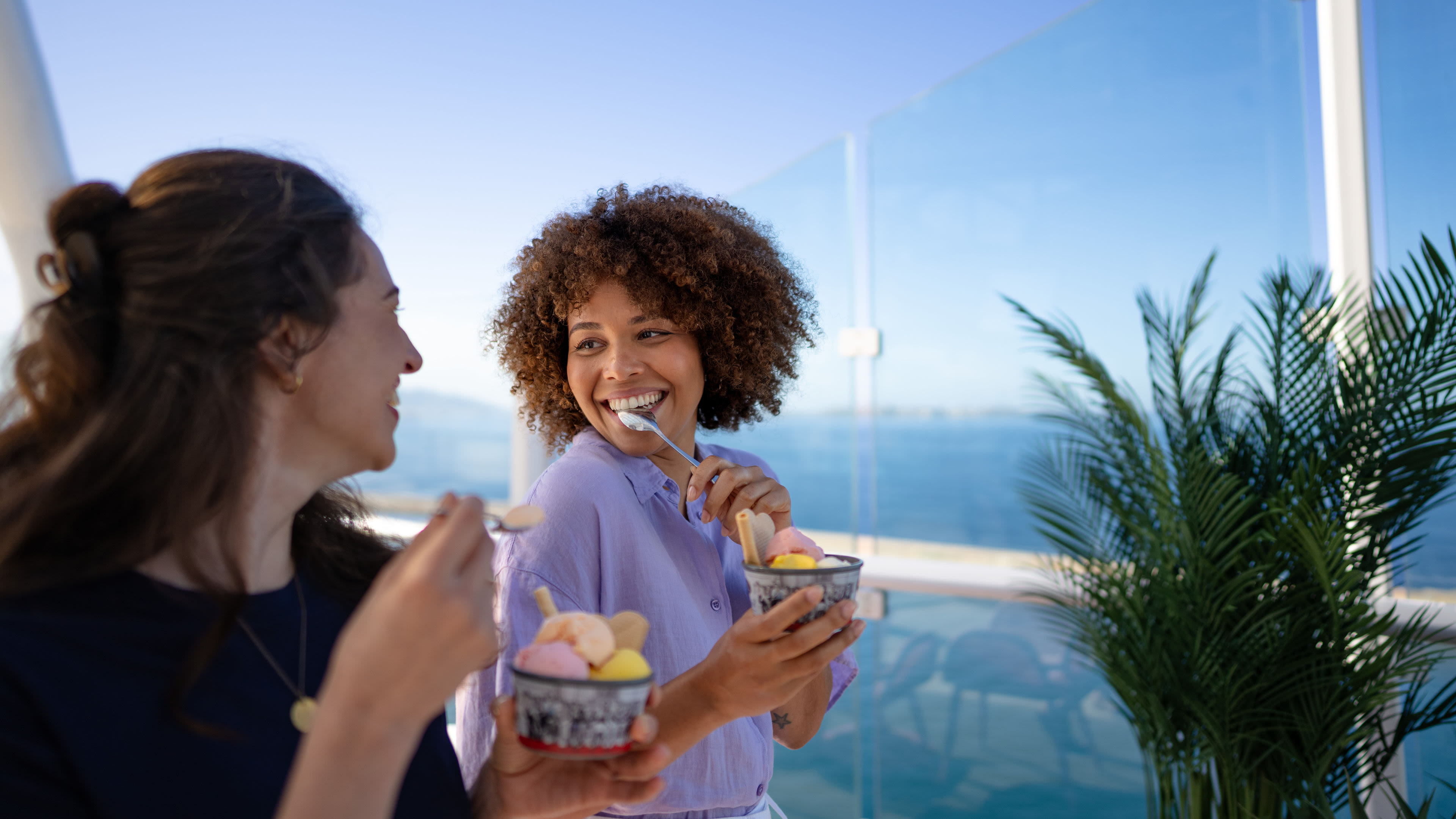 Zwei Frauen essen Eis mit Meerblick