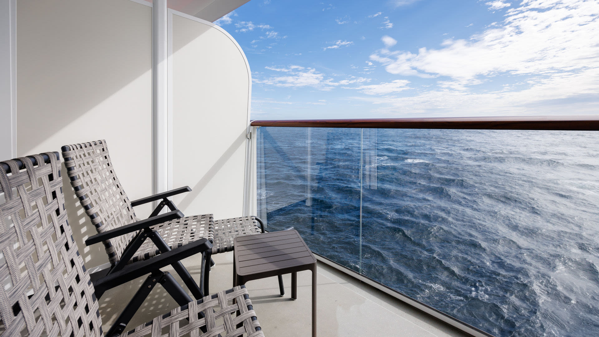 Balkon mit zwei Stühlen und Tisch, Blick aufs Meer.