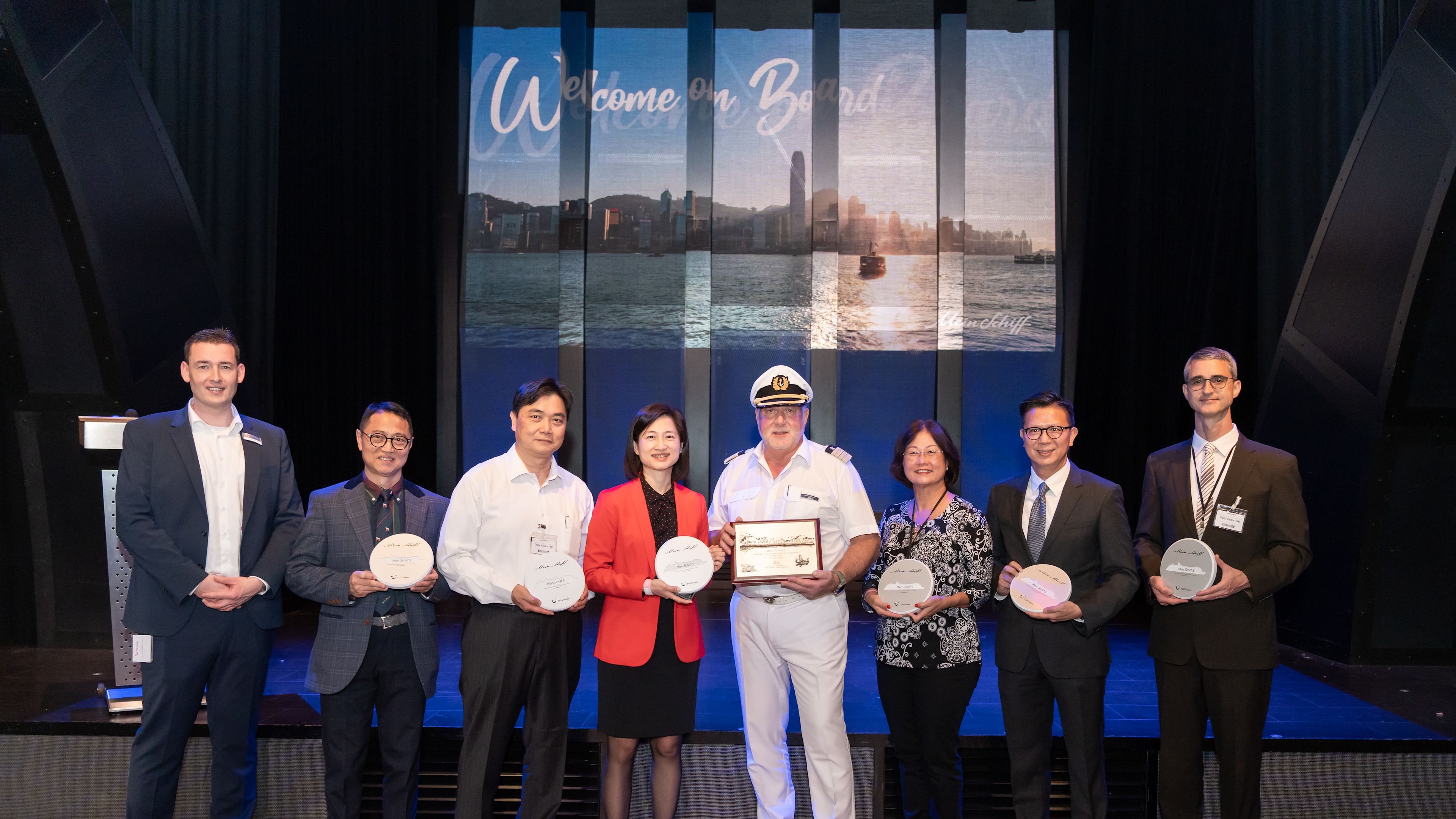 Kapitän Andreus Greulich Gruppe von acht Personen mit Auszeichnungen auf einer Bühne.