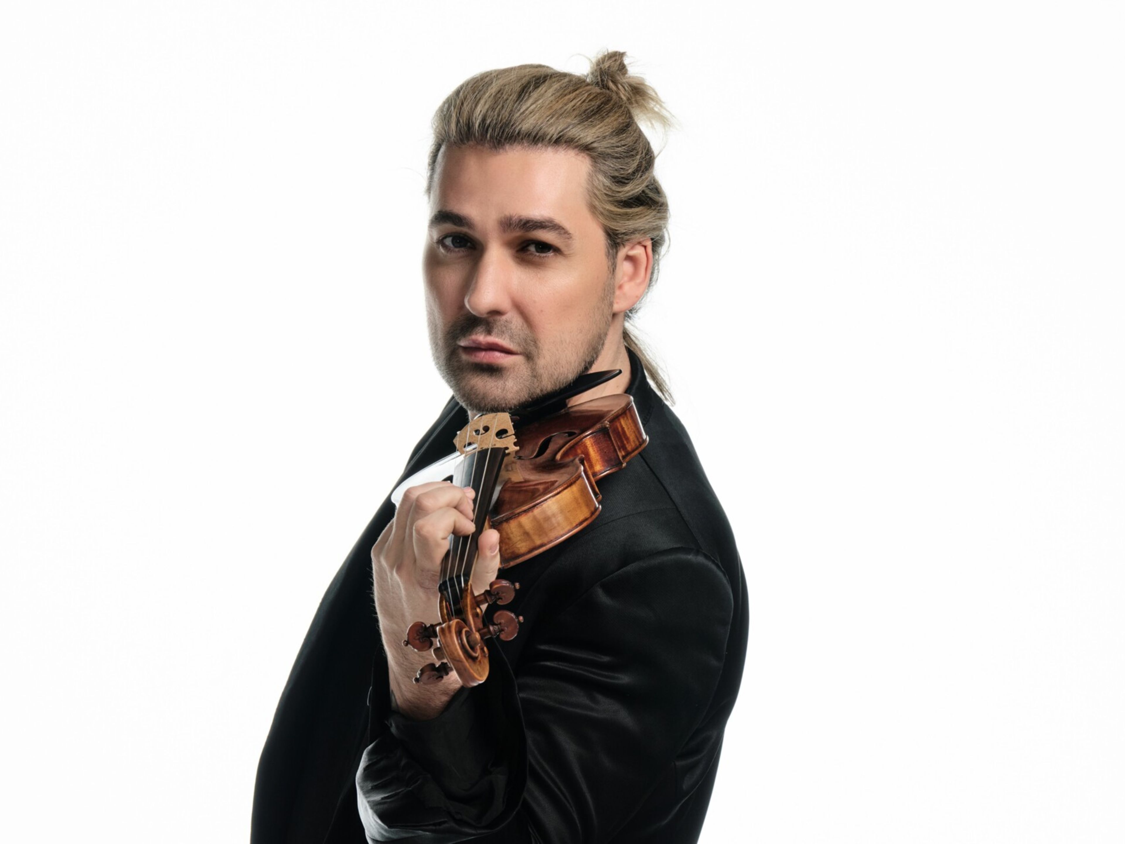 David Garrett 0227 red © Ben Wolf Universal Music Mann mit Geige in schwarzem Anzug vor weißem Hintergrund.