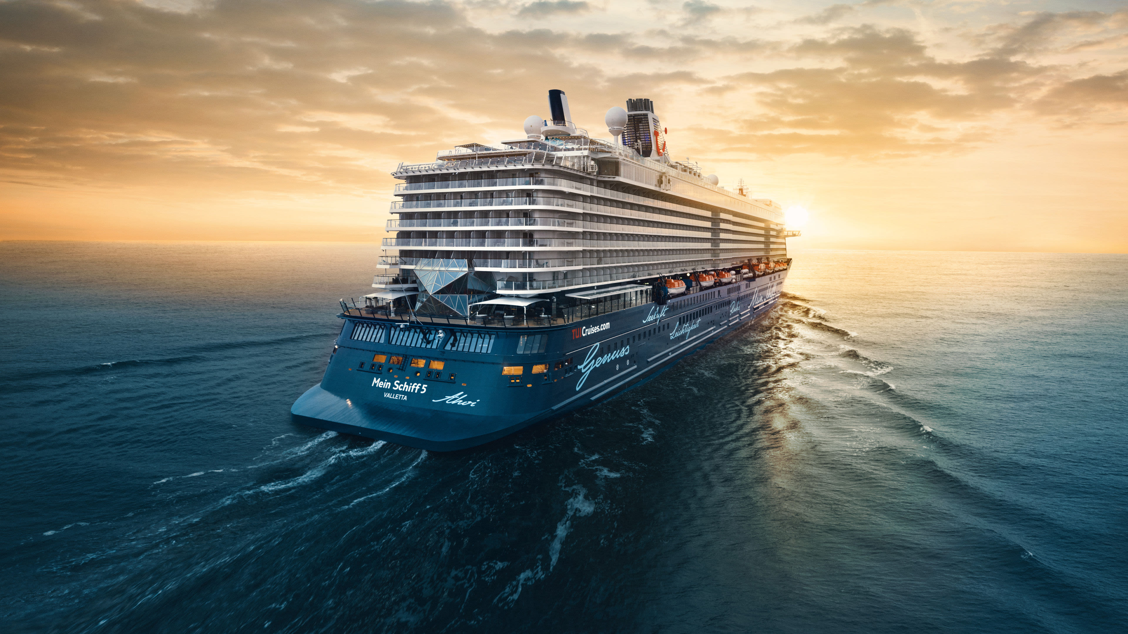 Kreuzfahrtschiff der Mein Schiff® Flotte bei Sonnenuntergang auf offenem Meer.