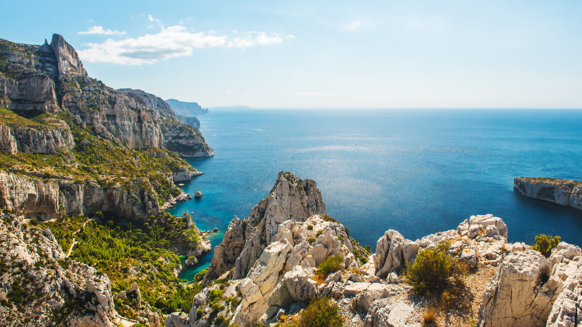 Küstenlandschaft der Calanques bei Marseille, blaues Meer, steile Felsen.