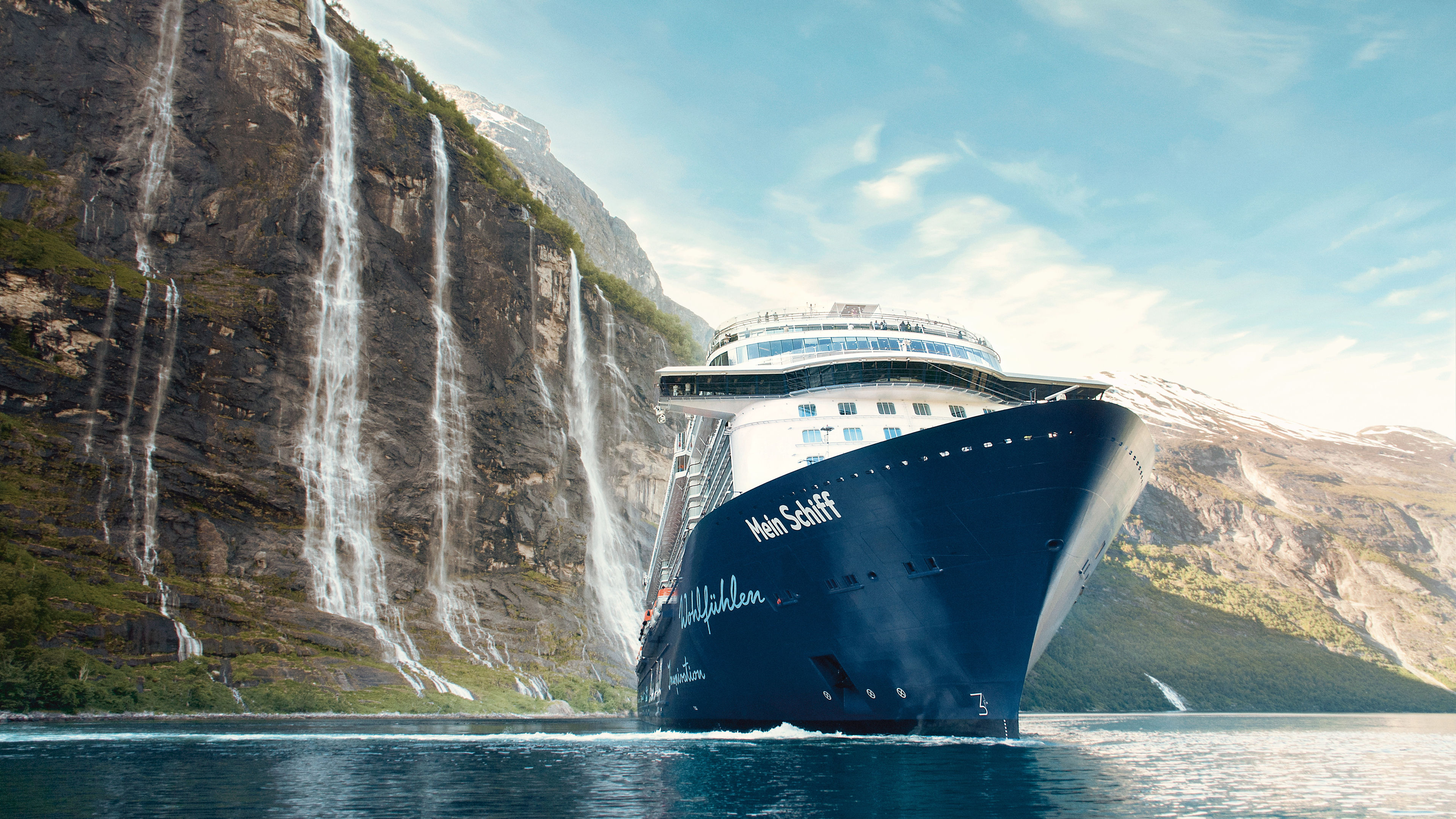 Kreuzfahrtschiff der Mein Schiff® Flotte vor norwegischen Wasserfällen.
