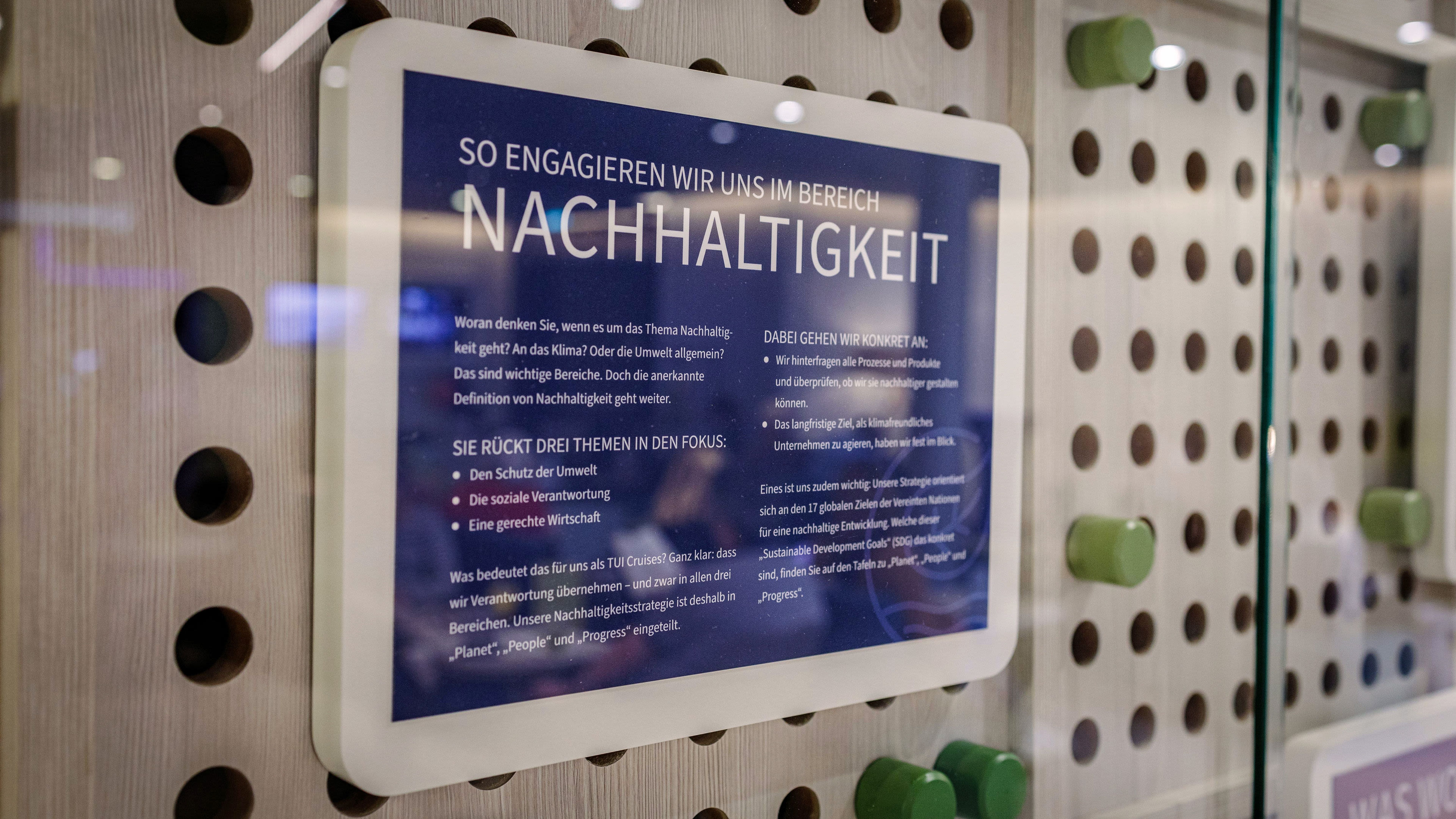 Schild mit Text über Nachhaltigkeit, blau-weißer Hintergrund, Holzdekor im Hintergrund. Schild mit Text über Nachhaltigkeit, blau-weißer Hintergrund, Holzdekor im Hintergrund.