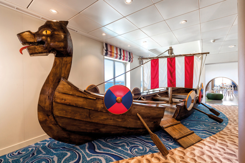 Wikingerschiff-Spielplatz mit rot-weißem Segel in Innenraum.