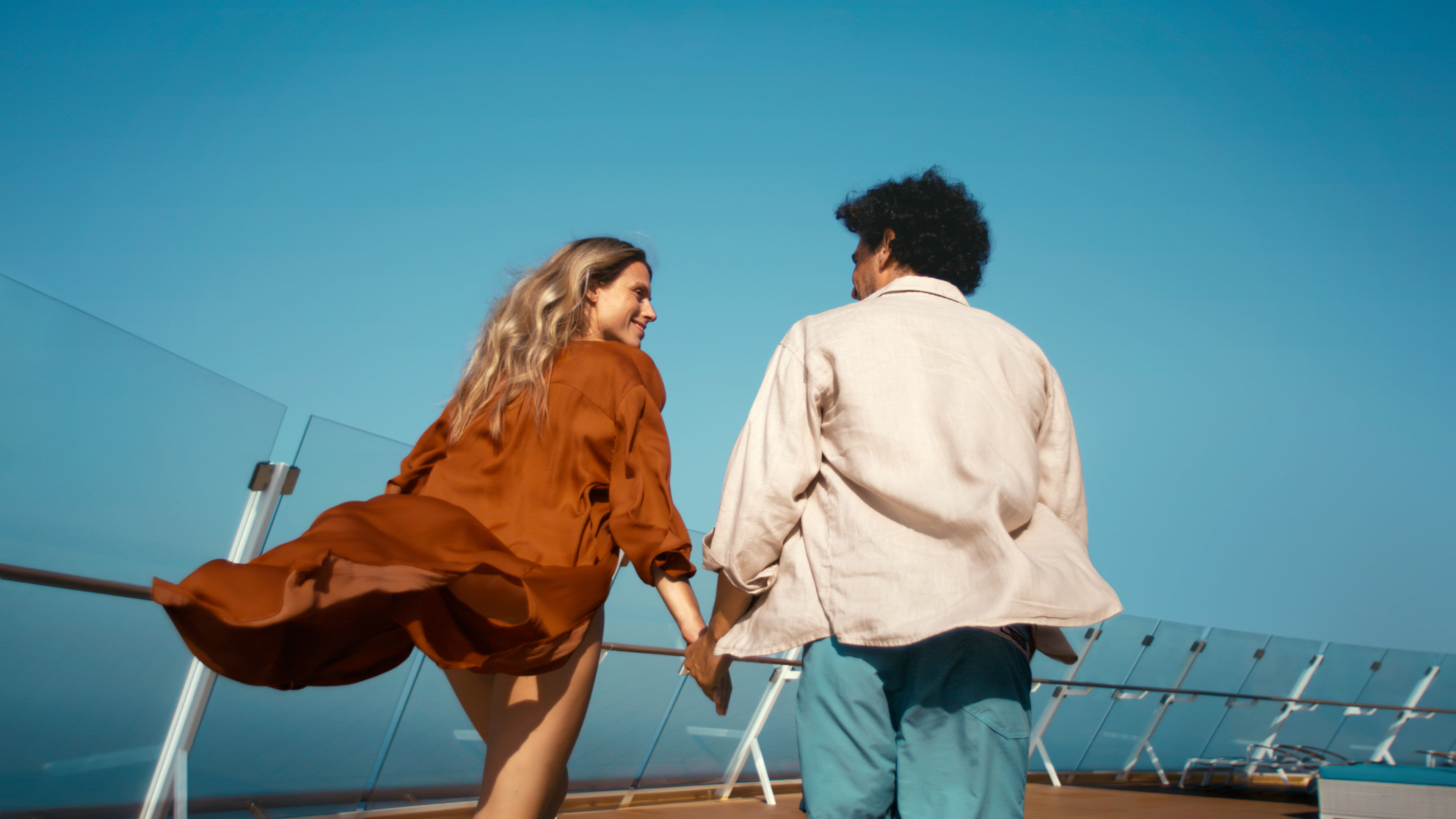 Paar hält Hände auf Kreuzfahrtschiff, blauer Himmel. Paar hält Hände auf Kreuzfahrtschiff, blauer Himmel.