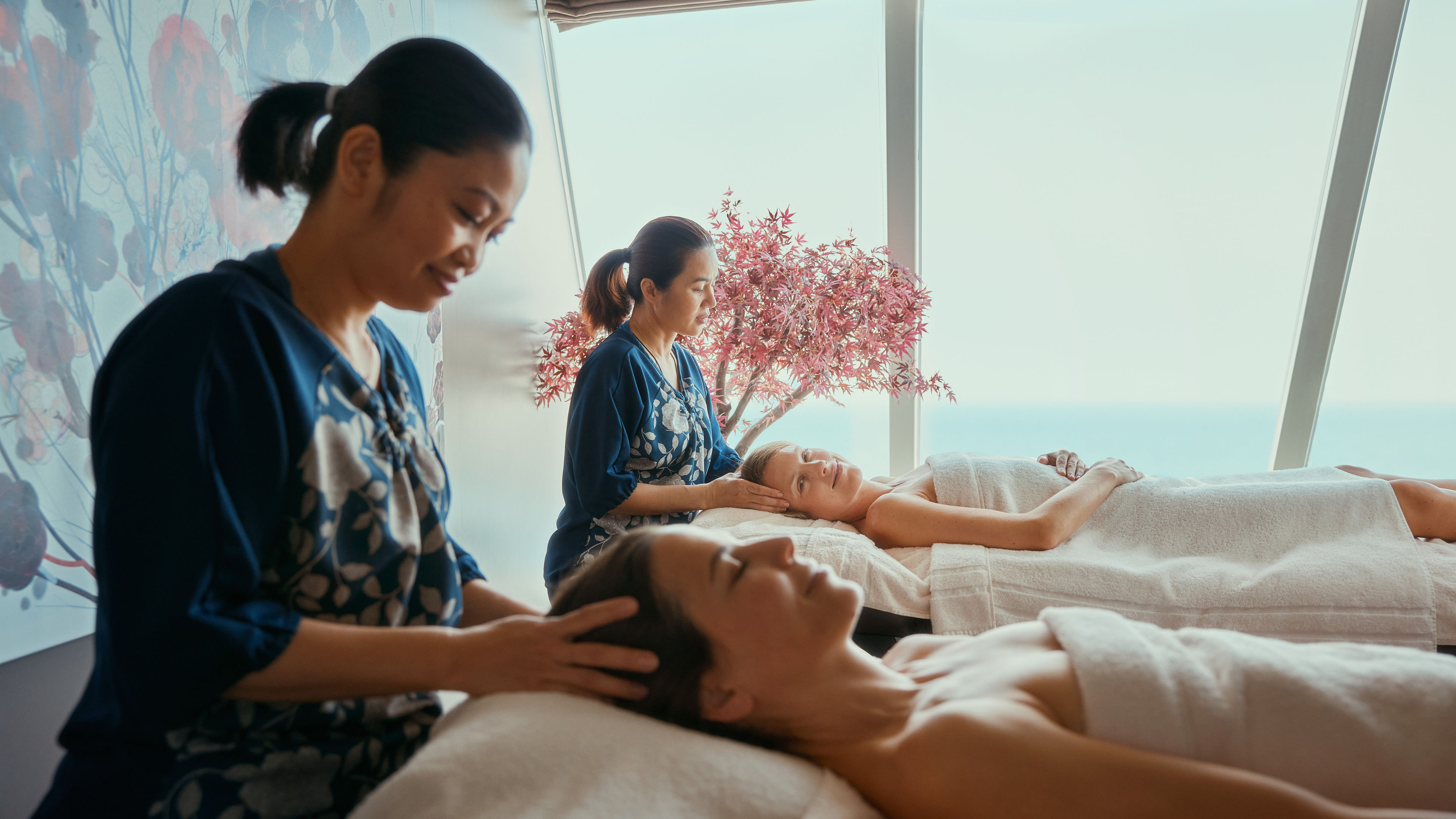 Zwei Frauen genießen Kopfmassagen in einem Spa.