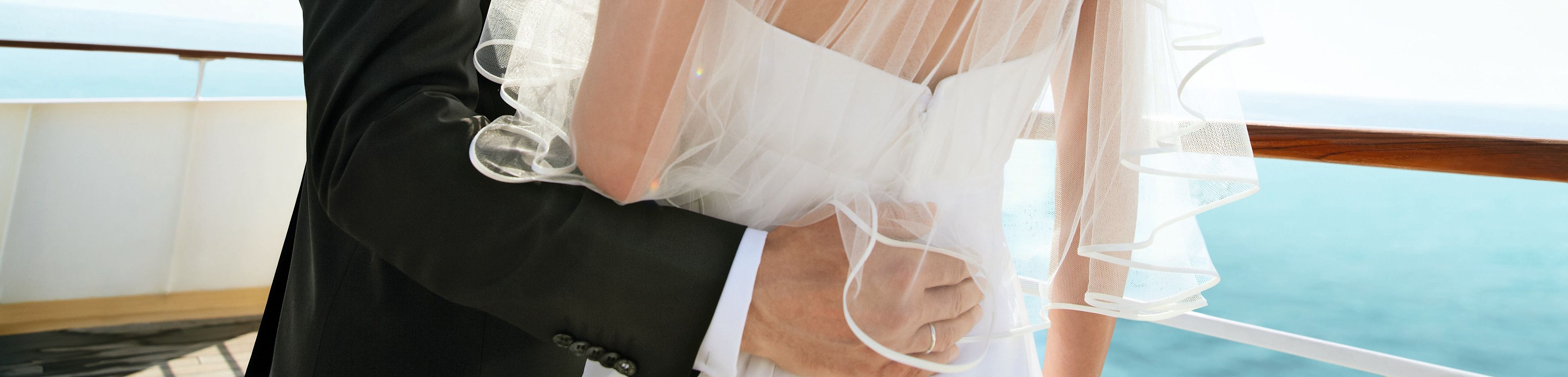 Brautstrauß mit weißen Rosen und Eheringe auf Kissen.