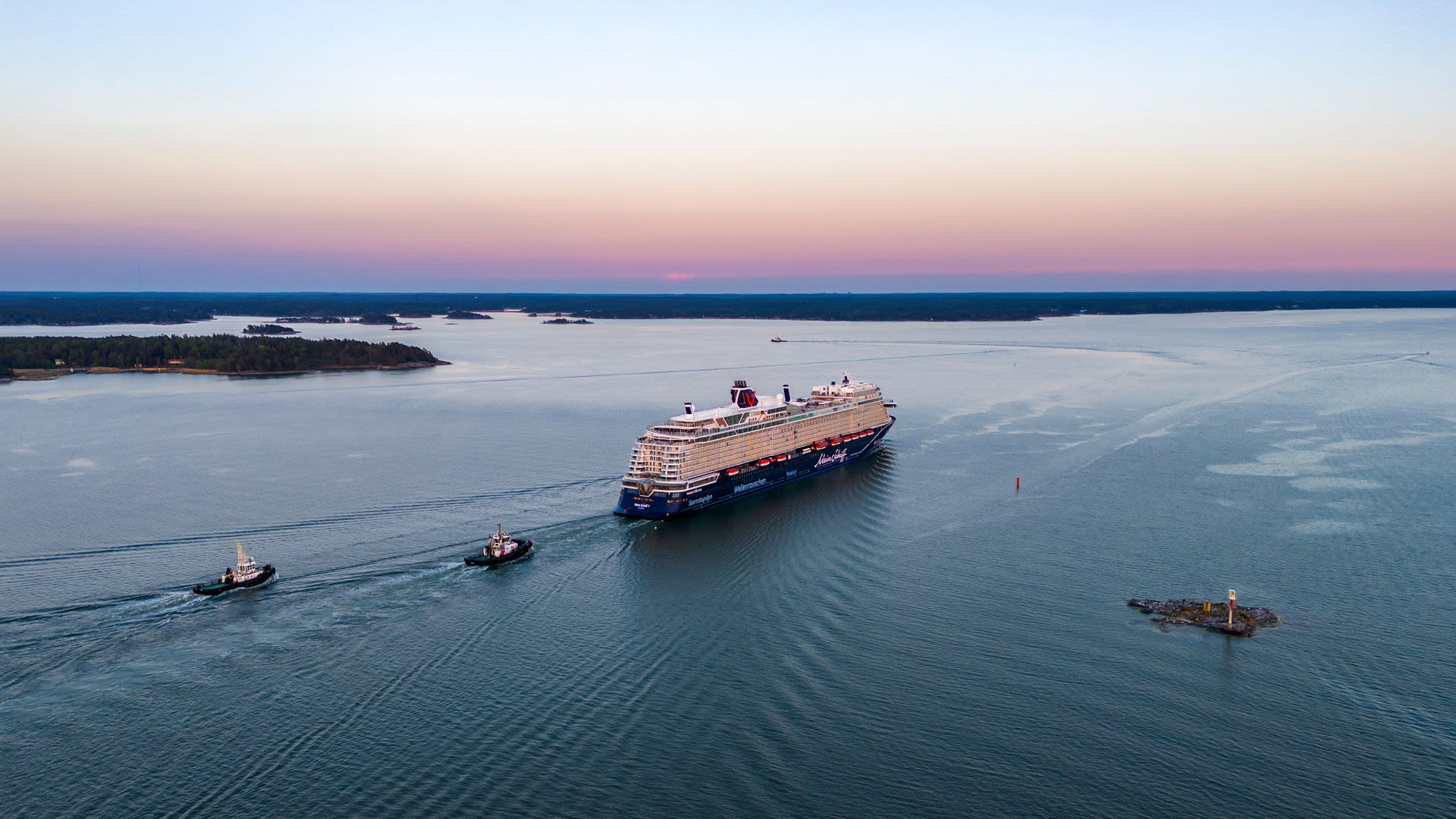 Kreuzfahrtschiff der Mein Schiff® Flotte bei Sonnenuntergang auf offenem Meer.